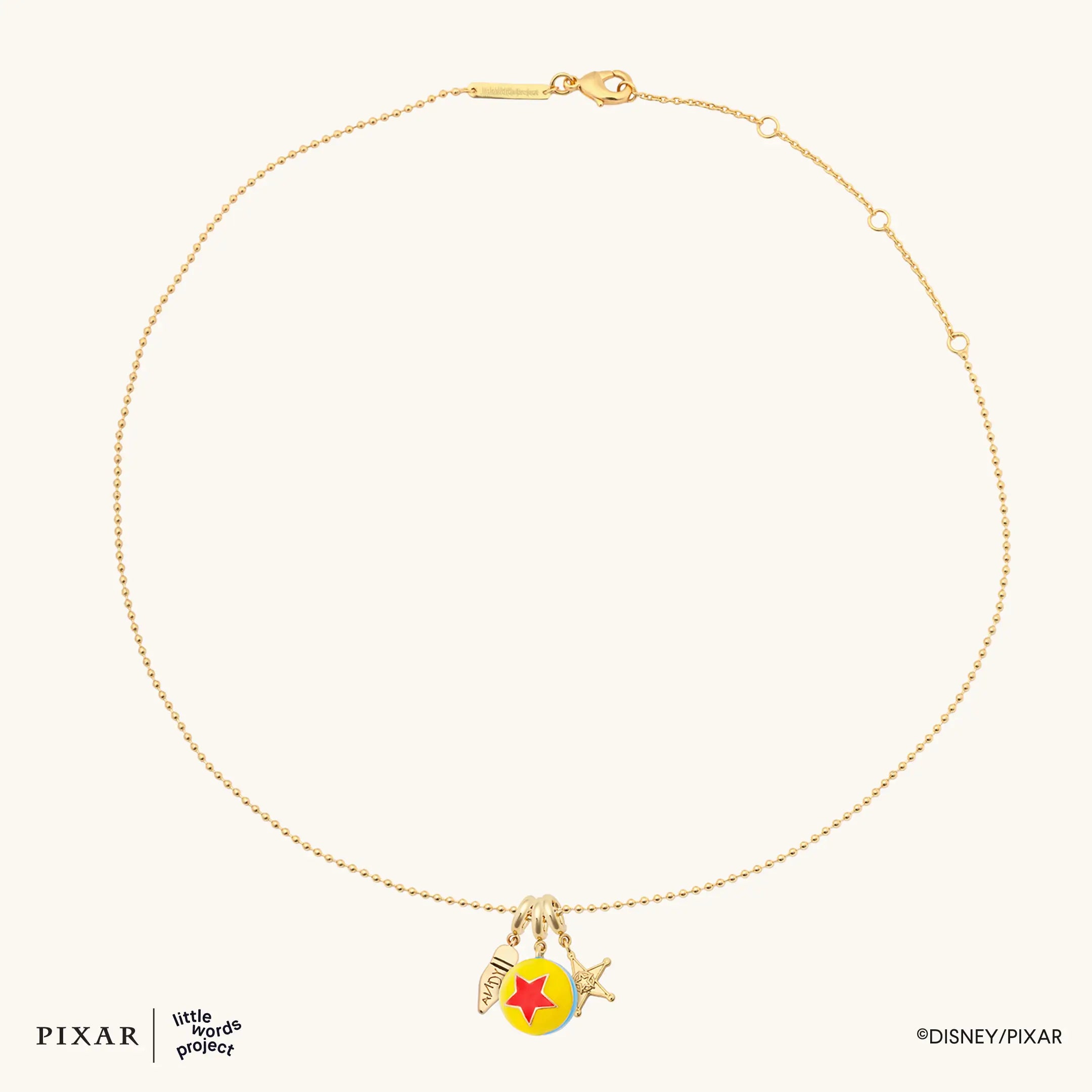 Reach for the Sky Toy Story charm necklace shown full as an oval with the gold charm cluster, flat lay