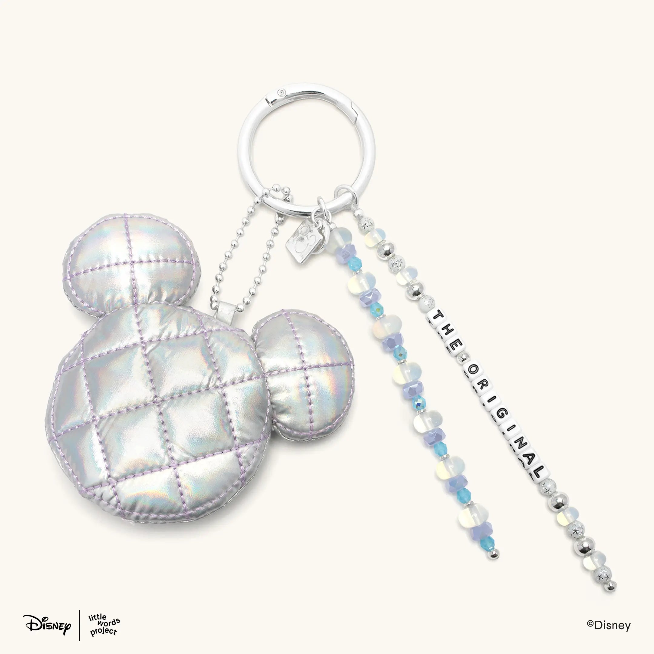 The OG Bag Charm from Disney Mickey and Friends on cream, iridescent quilted Mickey Mouse head on a silver ring with beaded The Original letter bead strands