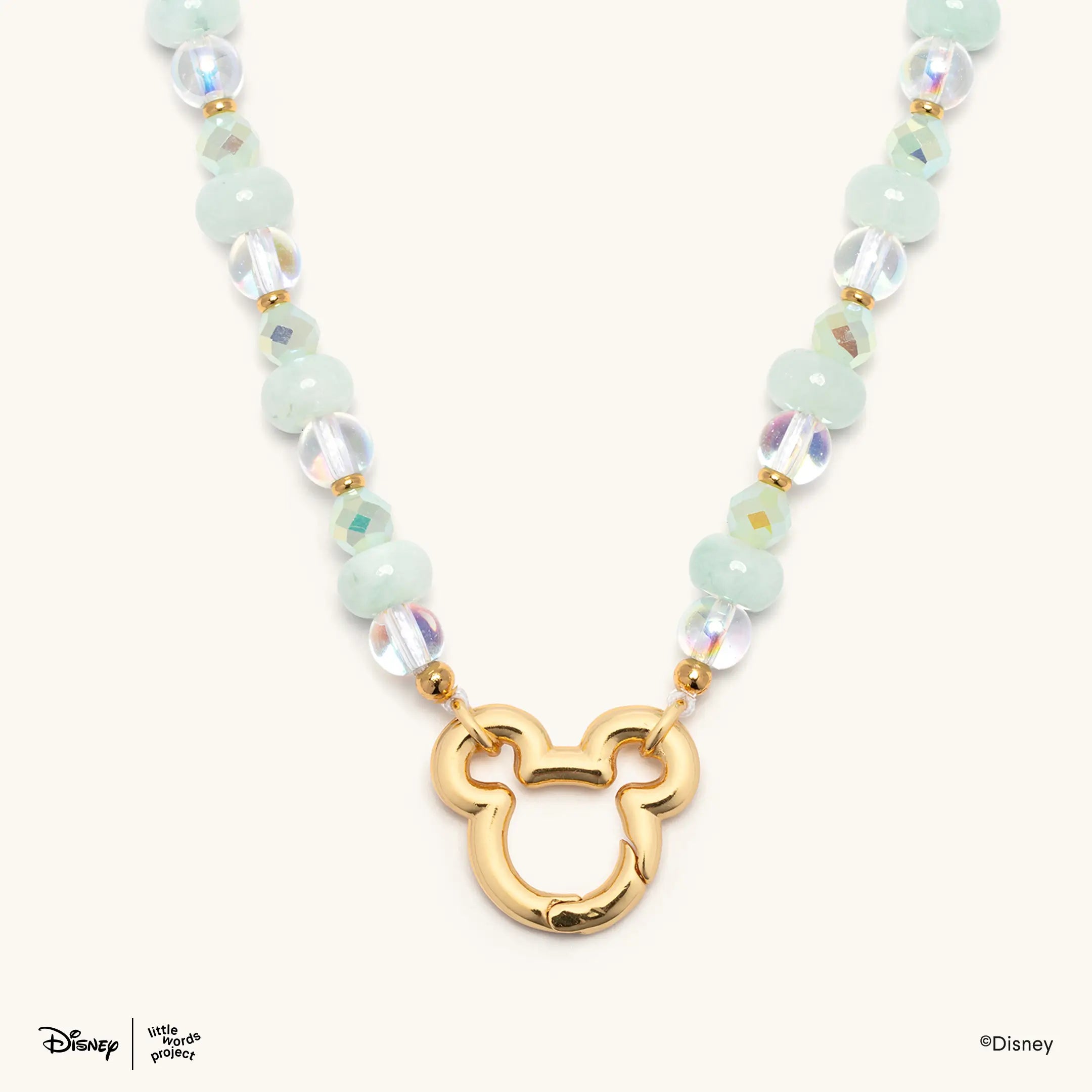 Mickey Mouse Charm Necklace Base from Disney Mickey and Friends, close up of the open gold plated Mickey Mouse pendant on mint green and iridescent beads