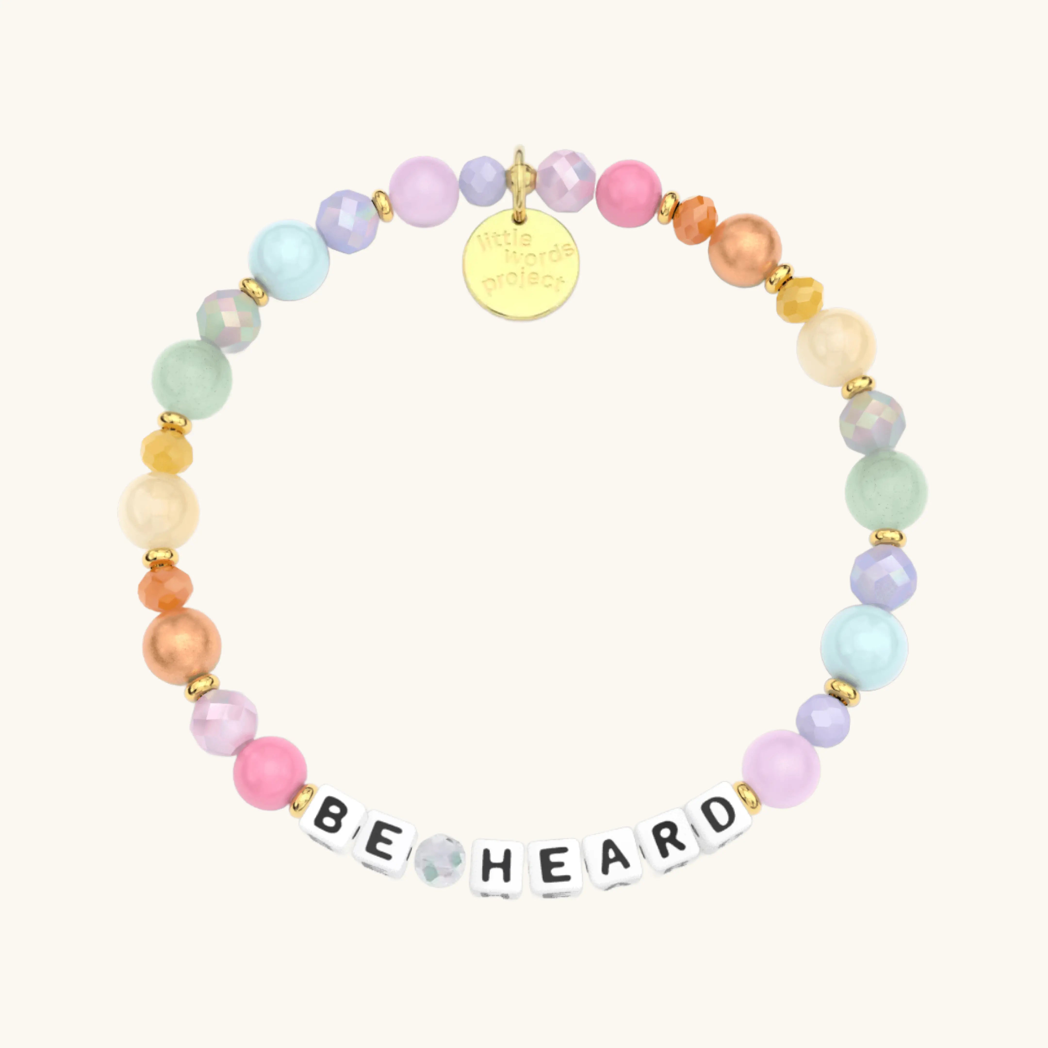Colorful beaded bracelet with 'BE HEARD' charm on a white background