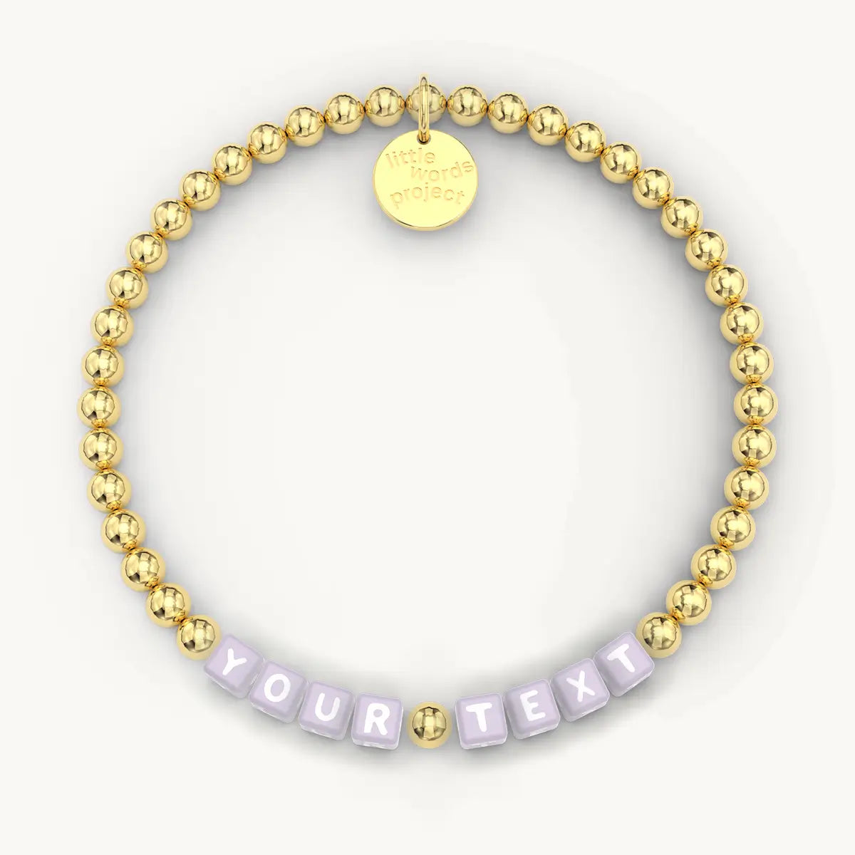 Gold beaded bracelet with a customizable text tag on a white background