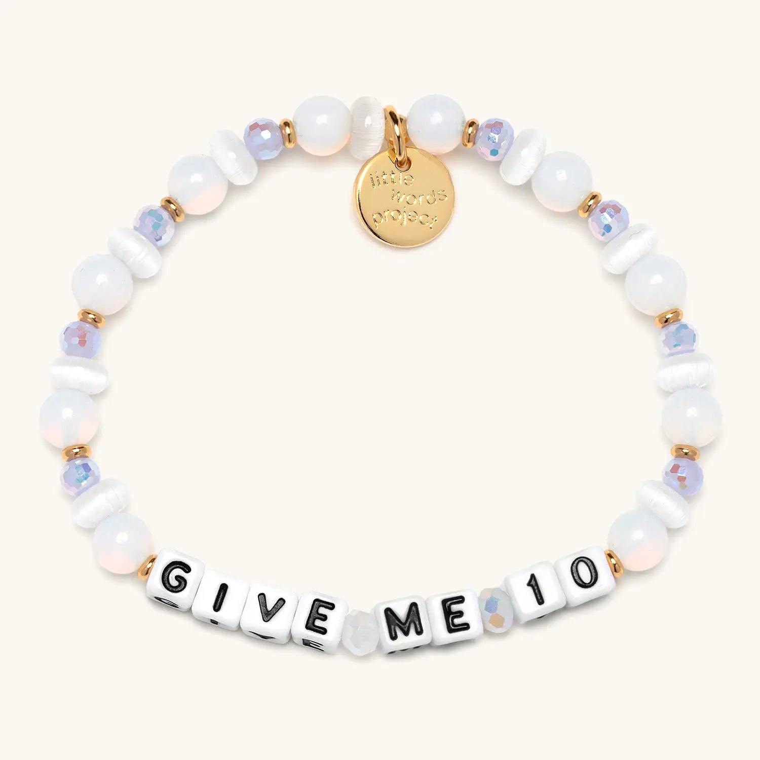 Give Me 10 word bracelet flat-lay on tan background with Little Words Project logo tag