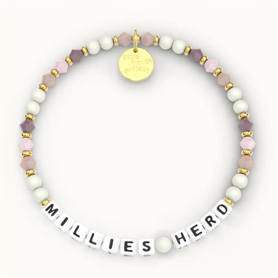Millie's Herd giveback bracelet in the Peachy Love bead pattern, white letter beads with cream pearls and mauve and blush crystal beads with gold accents, flat-lay on cream background