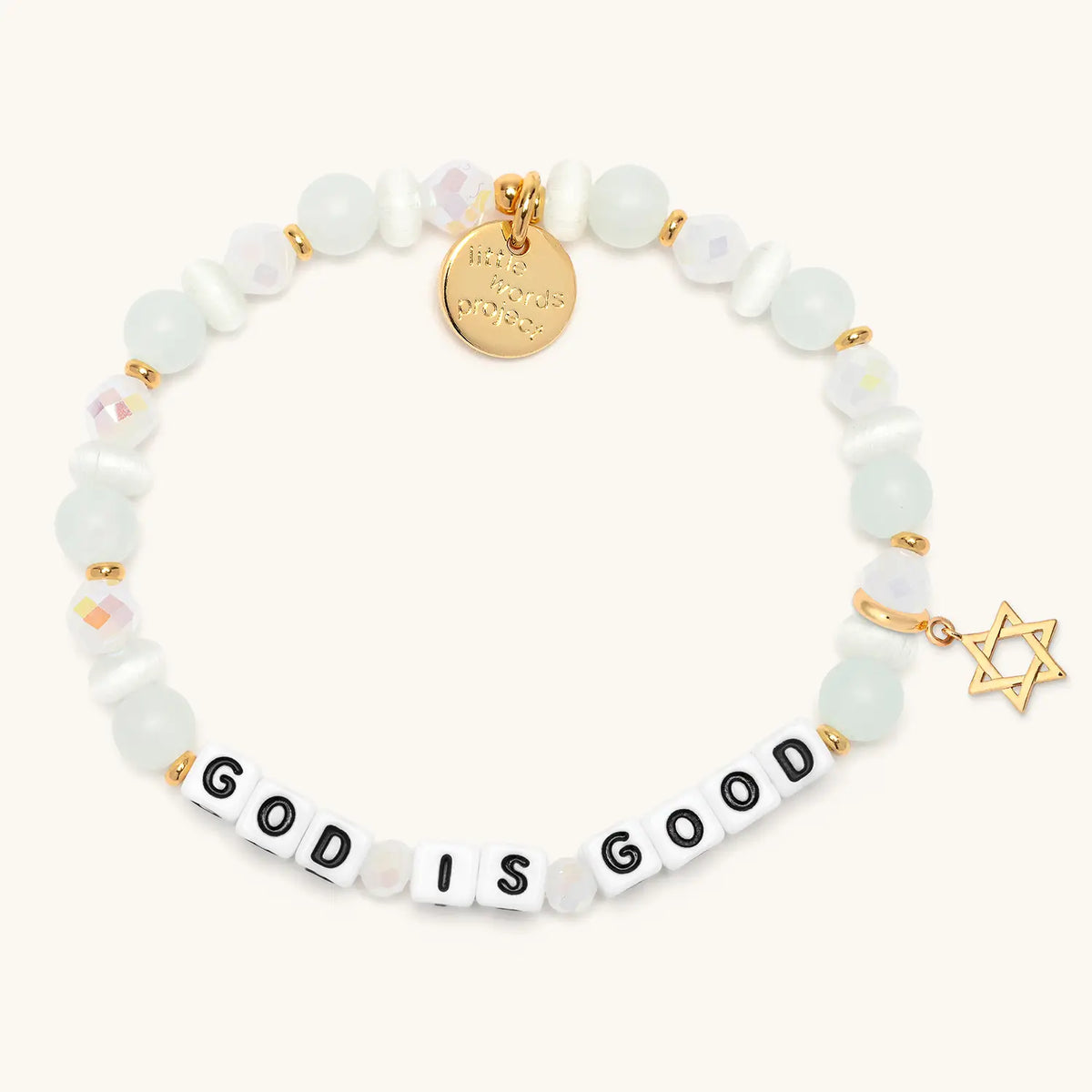 God is Good bracelet in the Luxe Knit bead pattern with white letter beads, gold Star of David charm, flat-lay on cream background