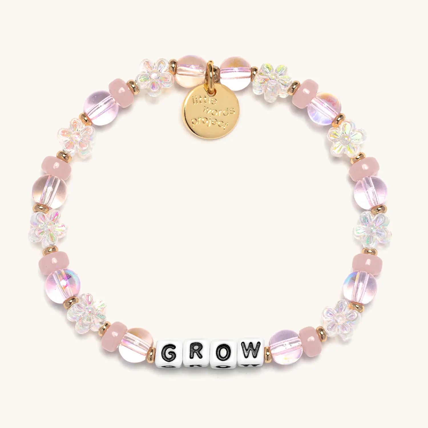 Bracelet with pink beads and 'GROW' charm on a white background
