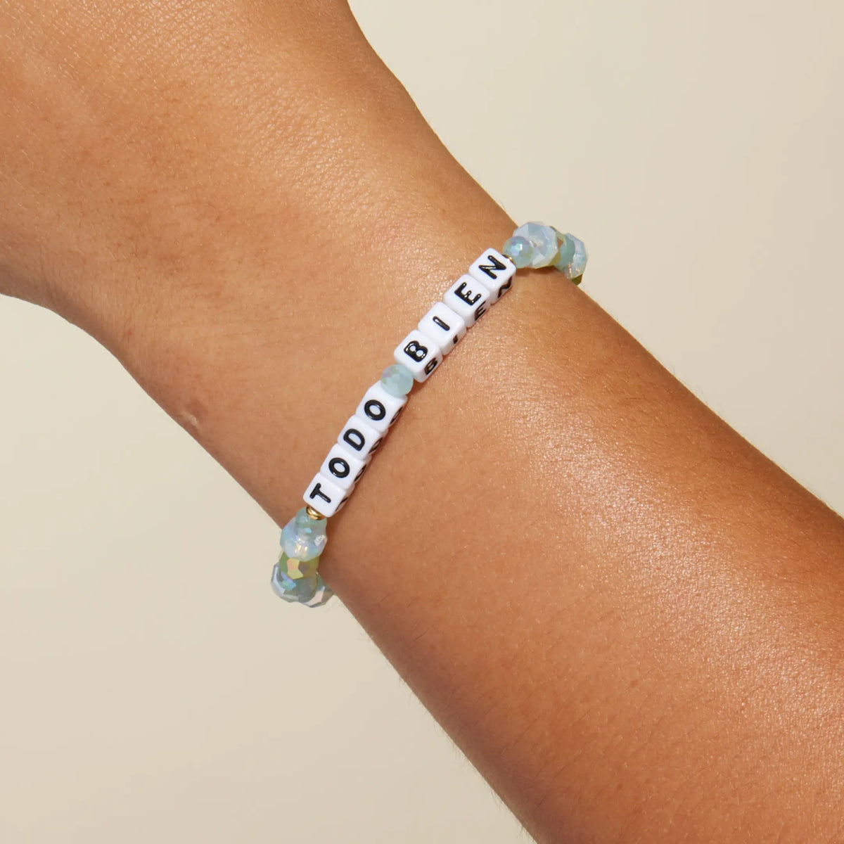 Todo Bien Alexia Del Valle bracelet worn on wrist, mint green and opal white beads with white letter beads