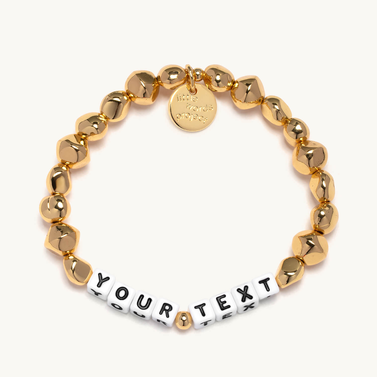 Gold beaded bracelet with a customizable text tag on a white background