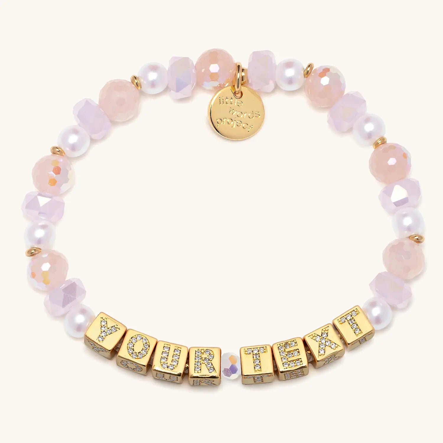 Bracelet with pink beads and gold letter beads spelling 'YOUR TEXT'.