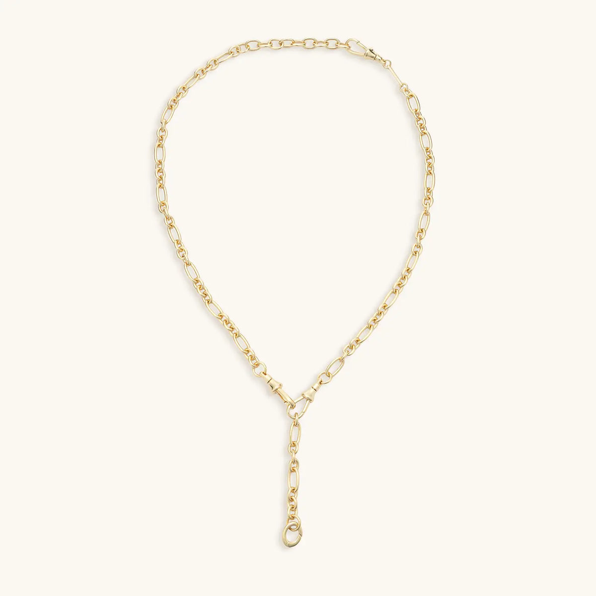 Lariat Convertible Necklace, 16k gold-plated mixed link chain lariat with a Y-drop and clasp ring for charms, flat-lay on cream background