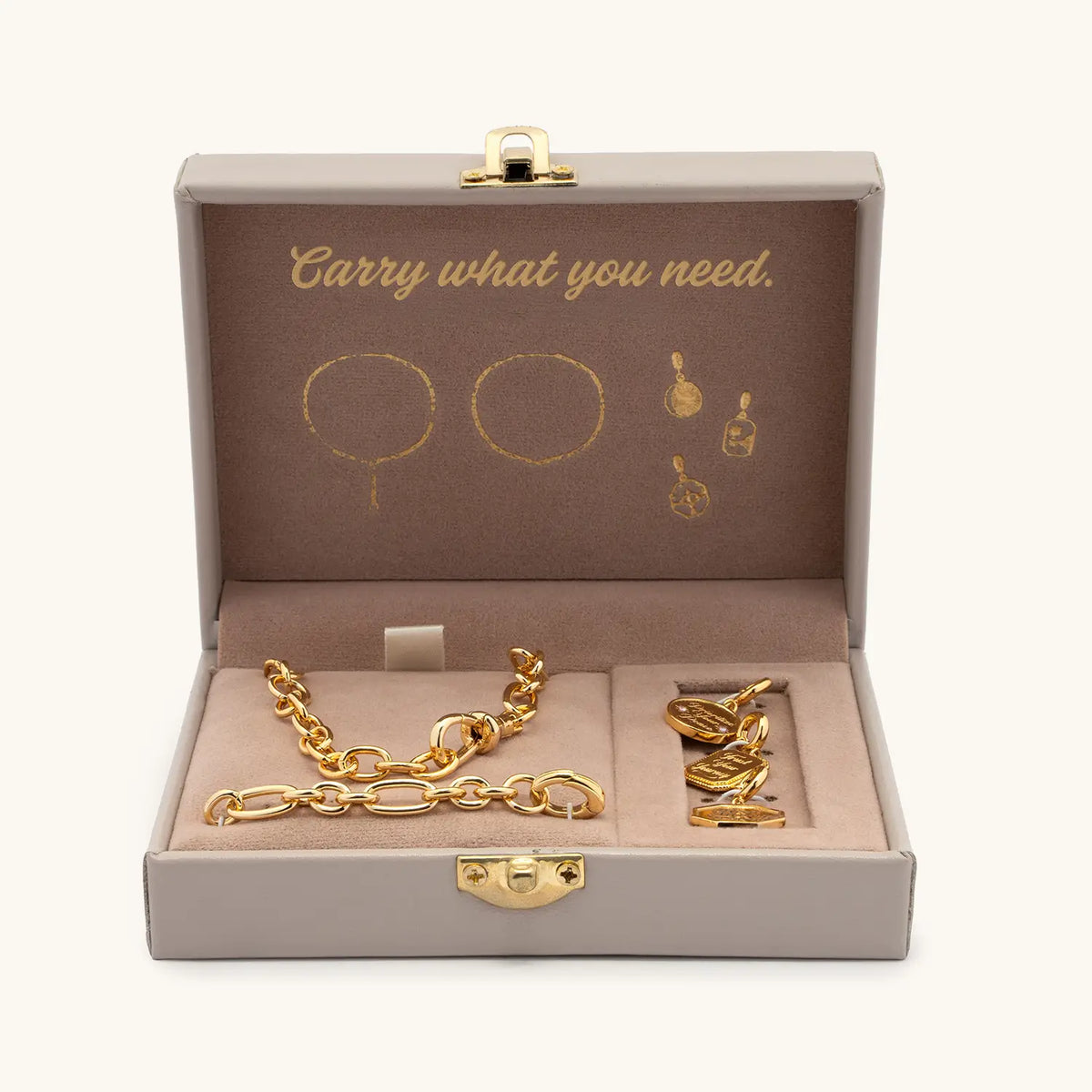 Lariat Charm Set open trunk box reading Carry what you need, with the gold lariat necklace and three Medallion Mantras charms nestled inside, packaging shot on cream background