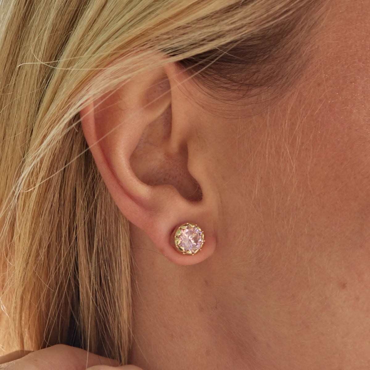 Blessed Scalloped Bezel Studs on-model, gold stud with a pink CZ stone in a scalloped bezel