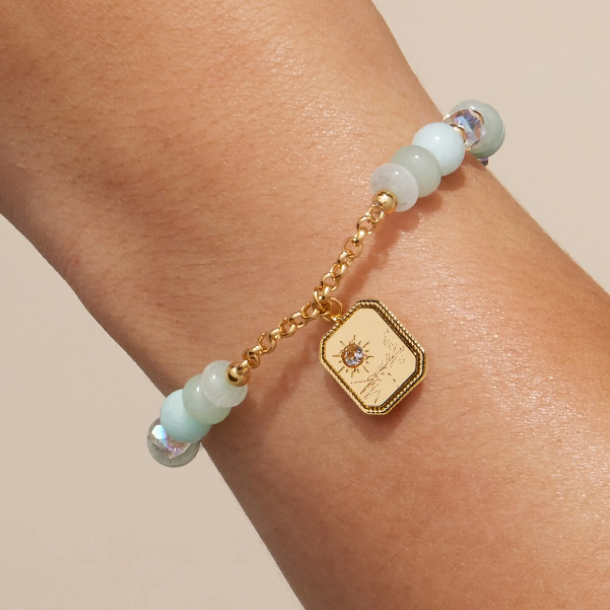 Trust Your Journey Charm Bracelet on-model, seafoam stone and clear crystal beads with gold chain and the CZ sun over a winding road side of the medallion facing out