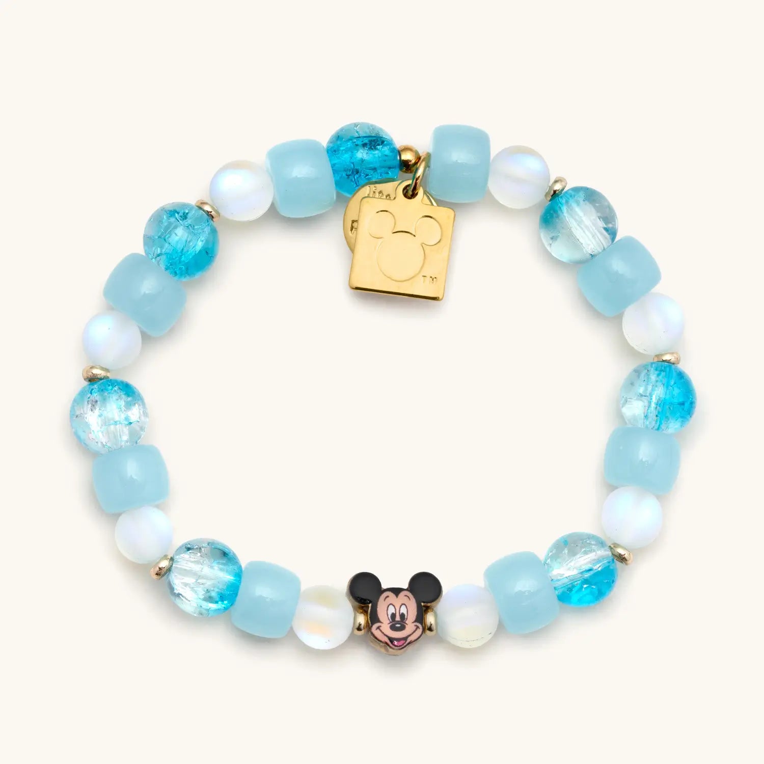 Bracelet with blue and white beads and a gold tag on a white background