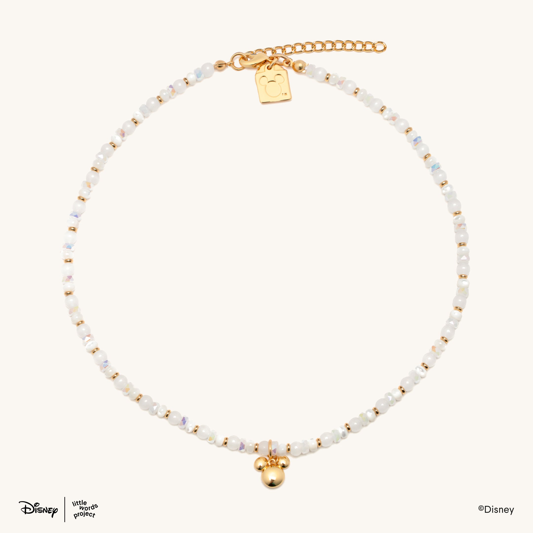 Mickey Mouse Charm Necklace from Disney Mickey and Friends laid flat on cream, full strand showing the gold plated extender chain and Mickey Mouse head pendant