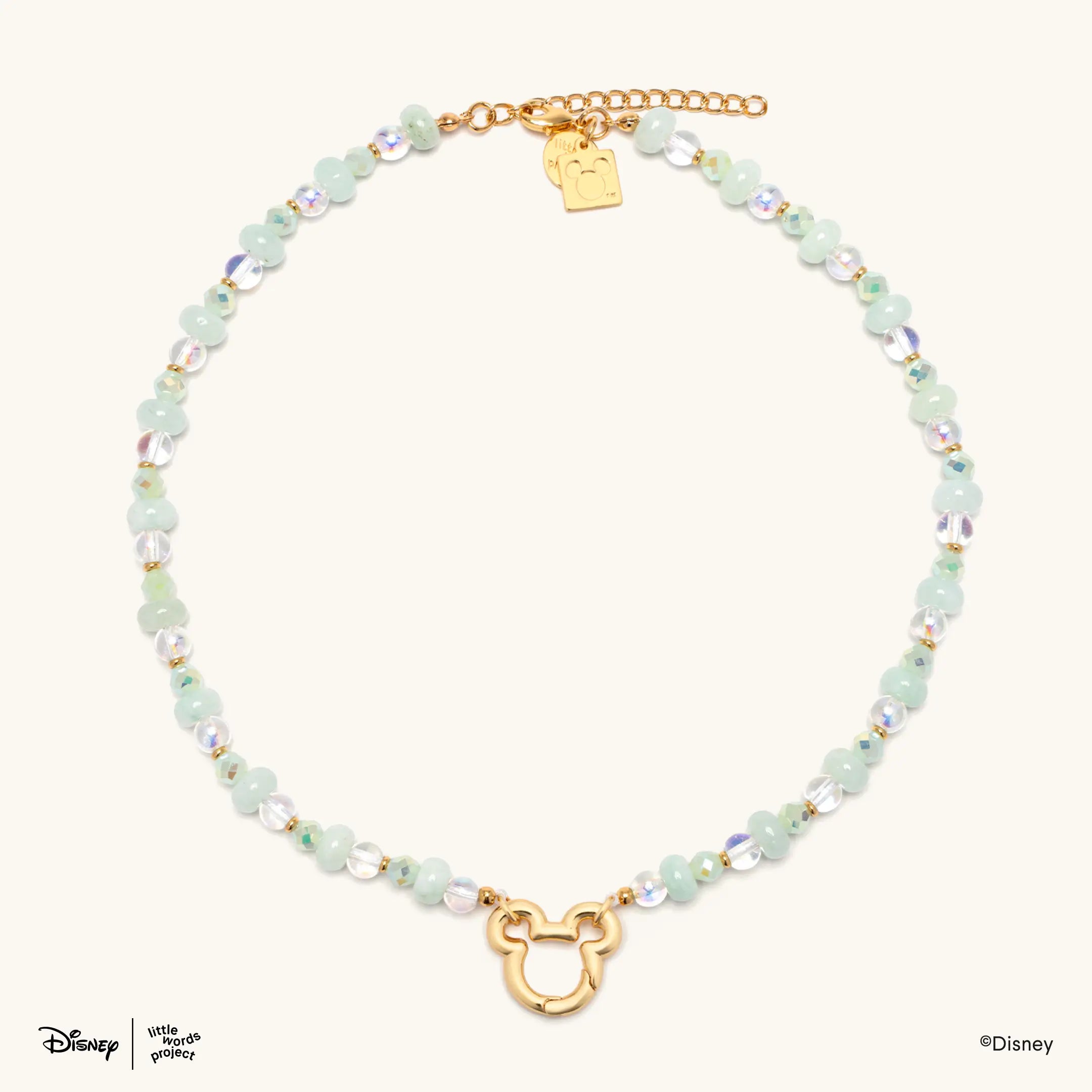 Mickey Mouse Charm Necklace Base from Disney Mickey and Friends, flat lay on cream with mint green and iridescent beads and an open gold plated Mickey Mouse pendant