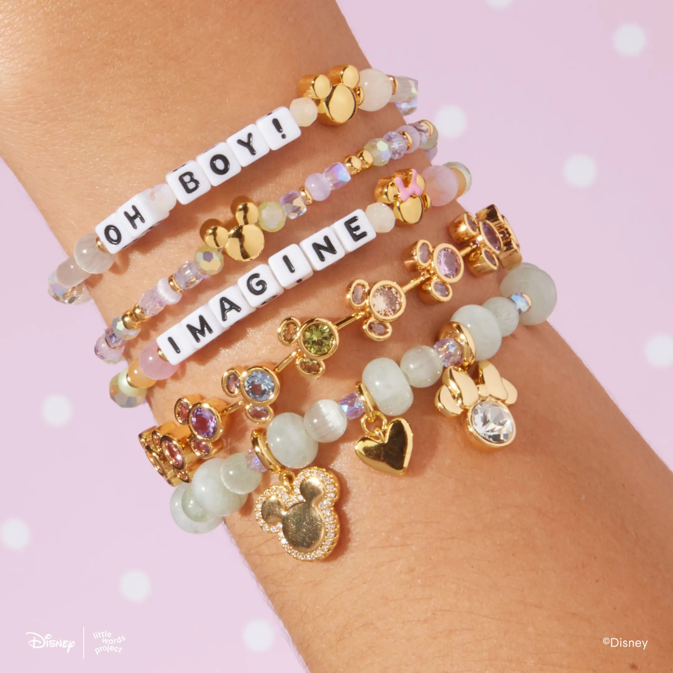 Disney Mickey and Friends bracelet stack worn on a wrist, Oh Boy! and Imagine letter bead bracelets layered with the Mickey Mouse and Minnie Mouse Charm Bracelet