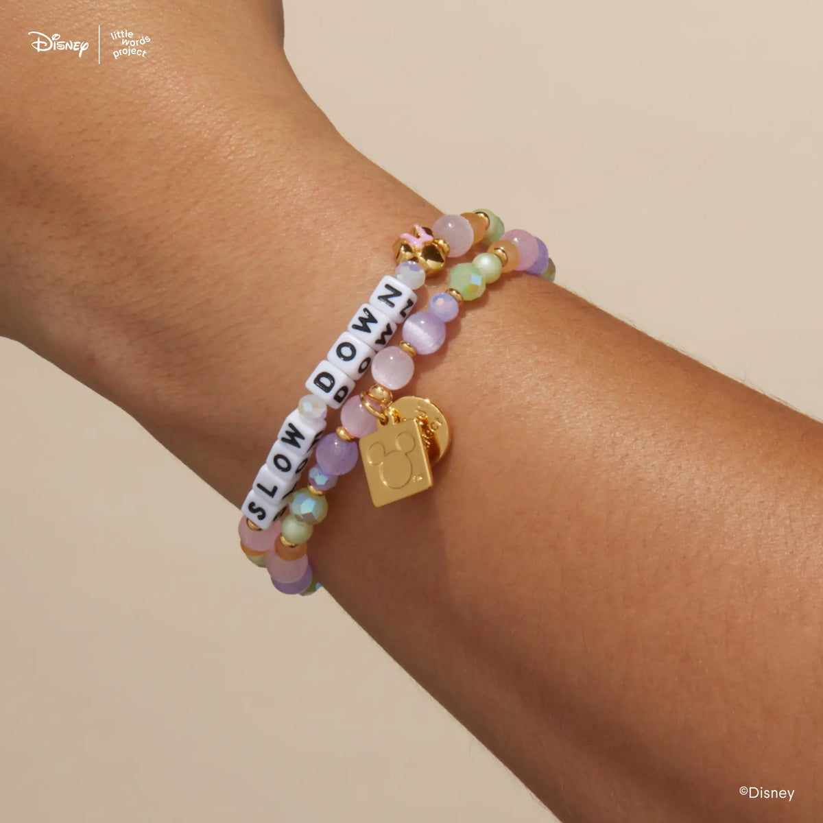 Minnie Custom Dot Darling Disney Mickey & Friends custom bracelets stacked on wrist, white letter bead version with pastel lavender, pink, mint, and peach beads and the gold Mickey Mouse logo tag