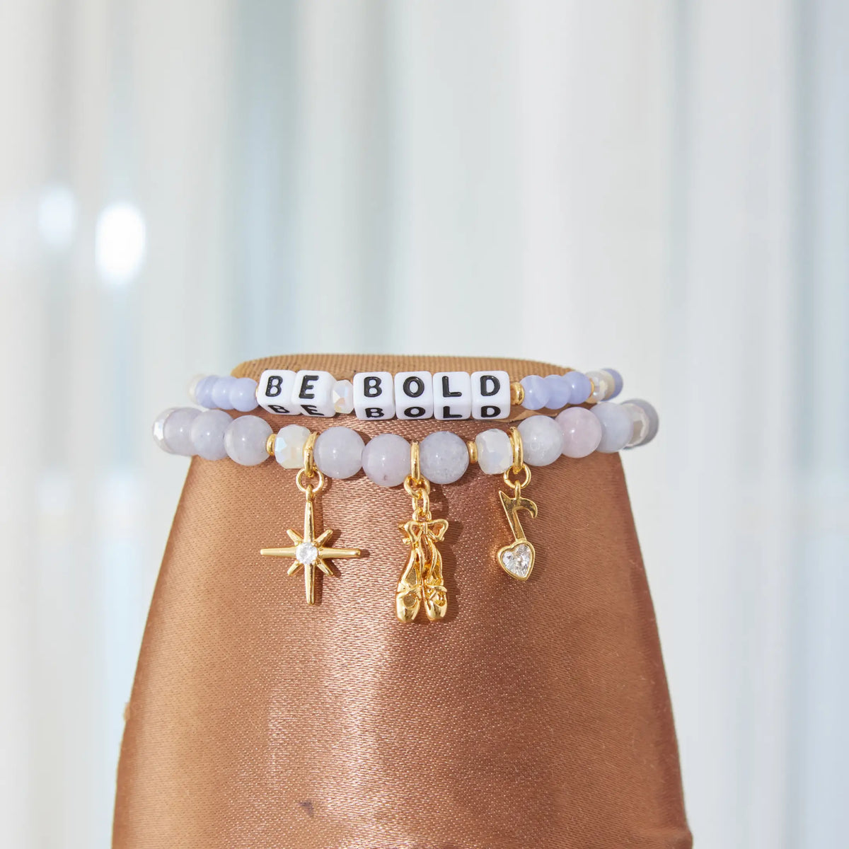 Be Bold and Swan Lake bracelets styled on a pointe shoe