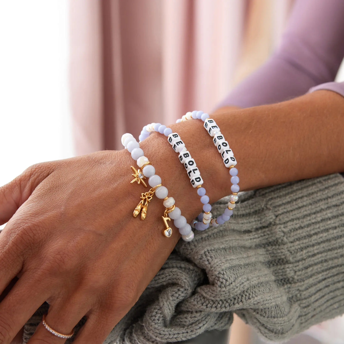 Close-up of Be Bold and Swan Lake bracelets stacked on wrist