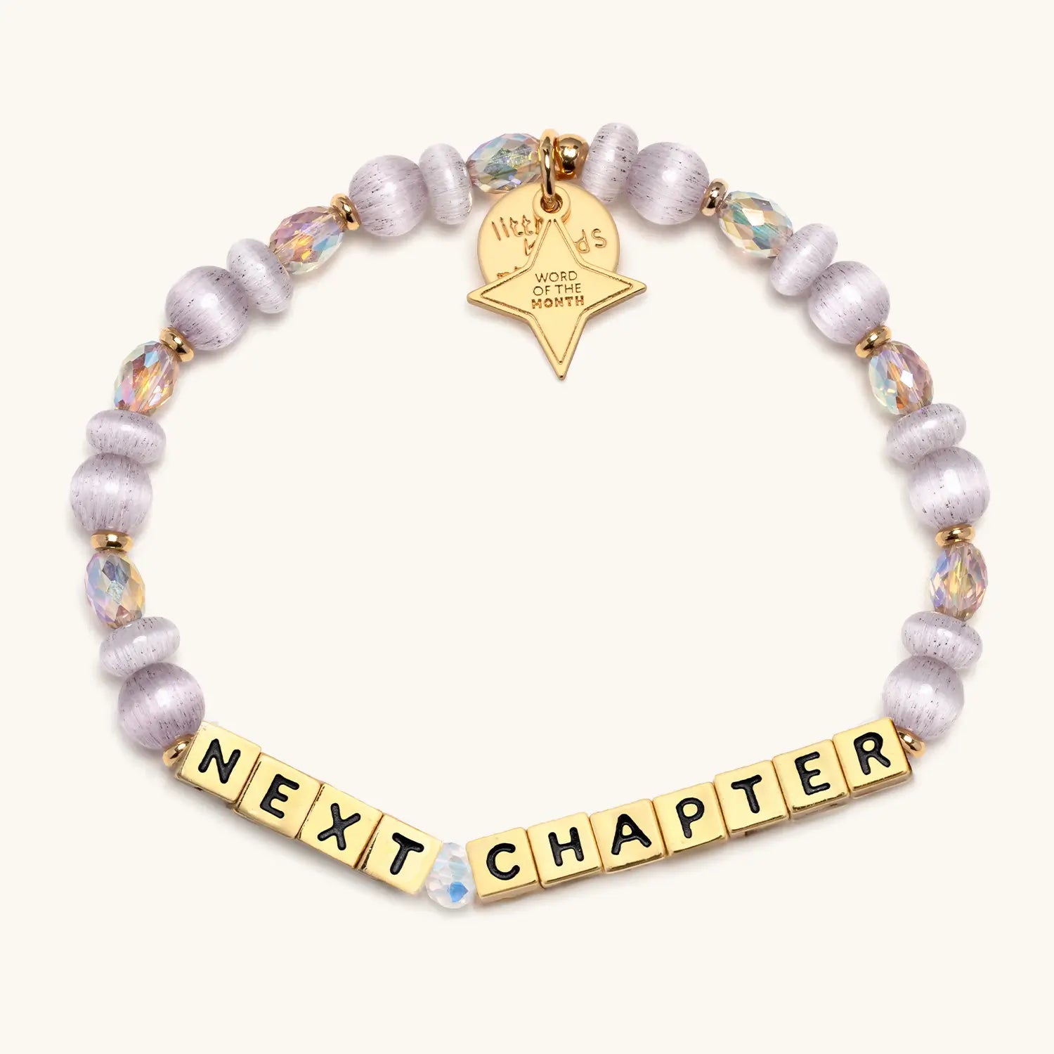 Bracelet with 'Next Chapter' and gold tag on a white background