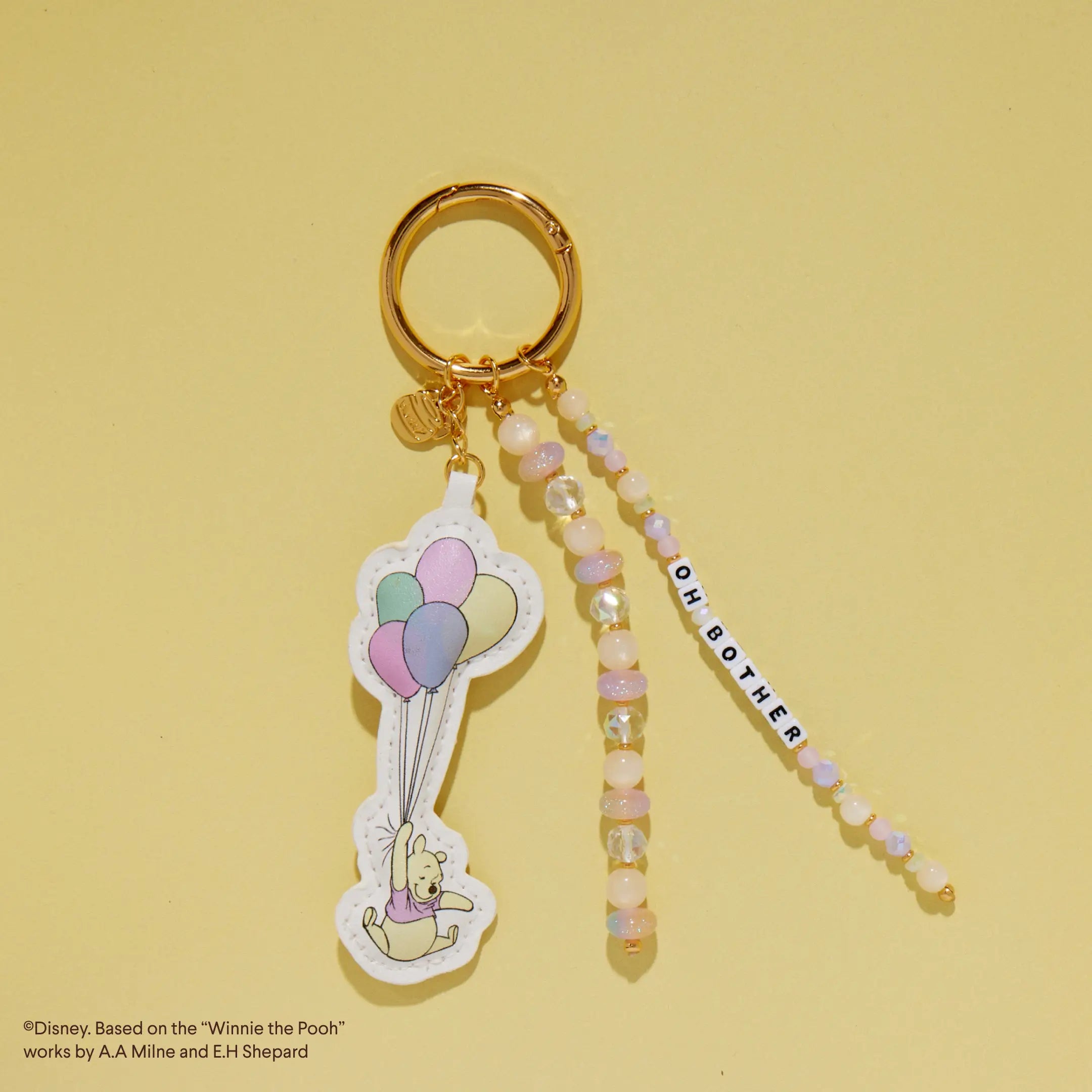 Bag charm with Winnie the Pooh design on a yellow background