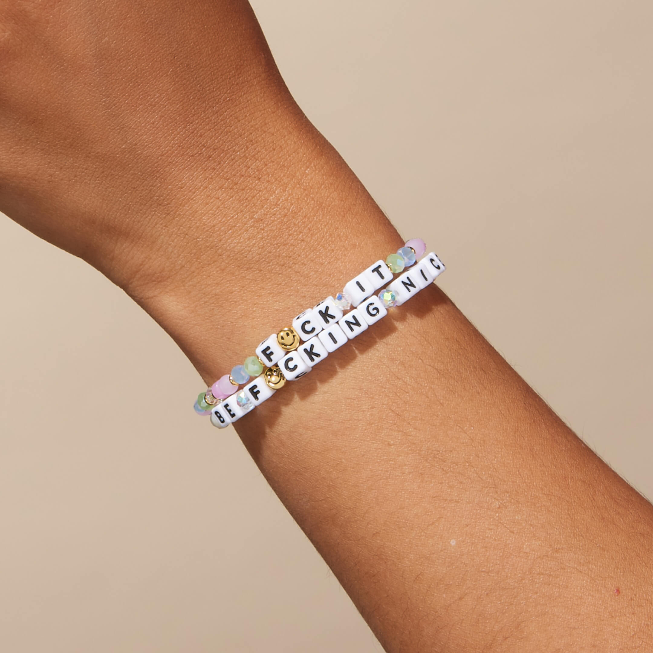Bracelets on a wrist against a beige background