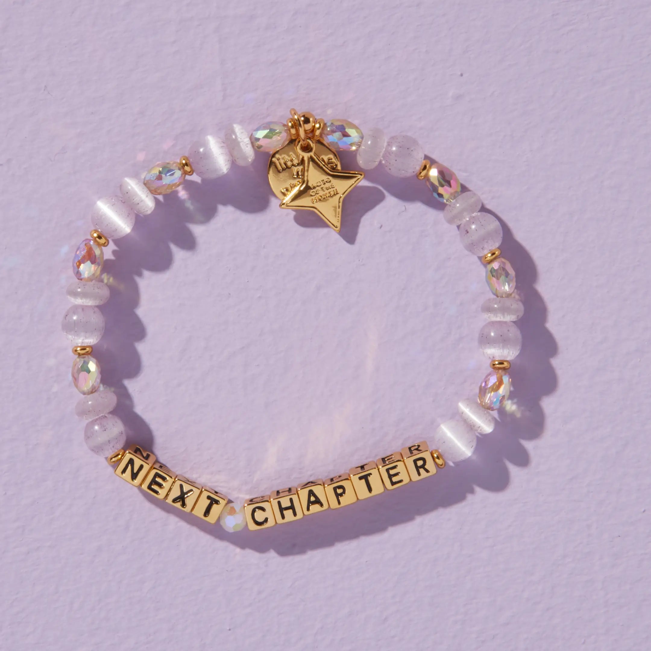 Bracelet with 'Next Chapter' on a light purple background