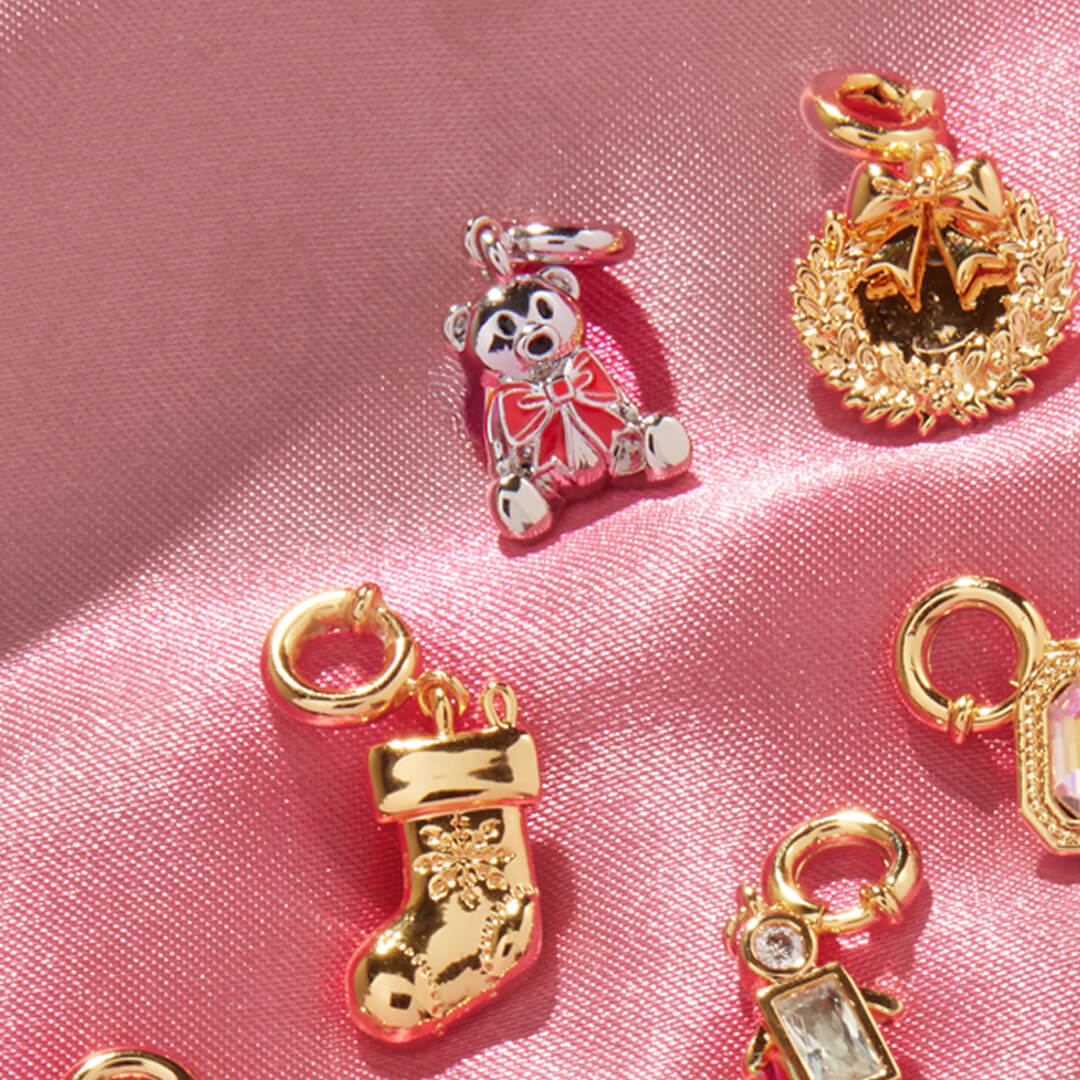 Gold and silver charms on a pink satin background