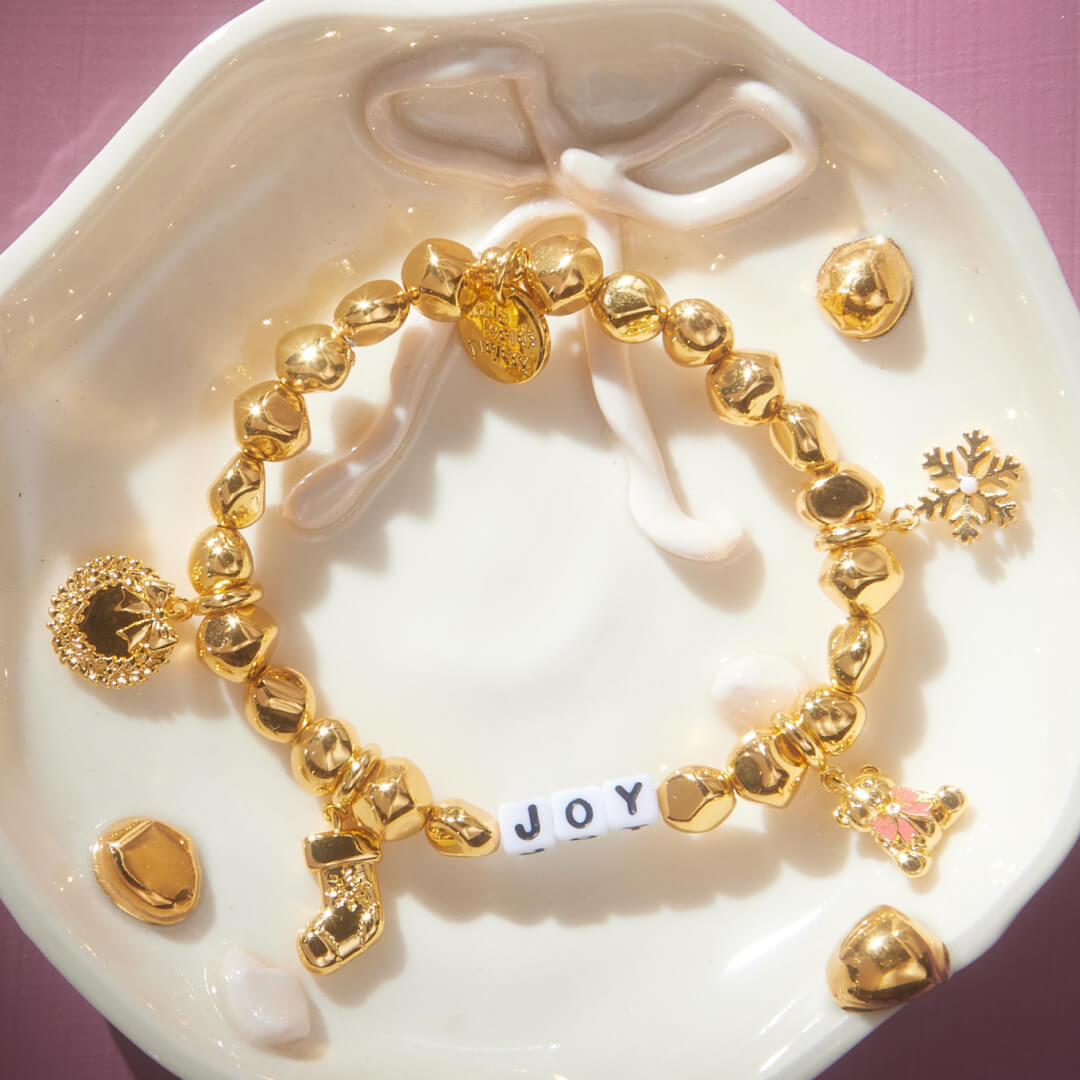 Gold bracelet with charms on a decorative dish