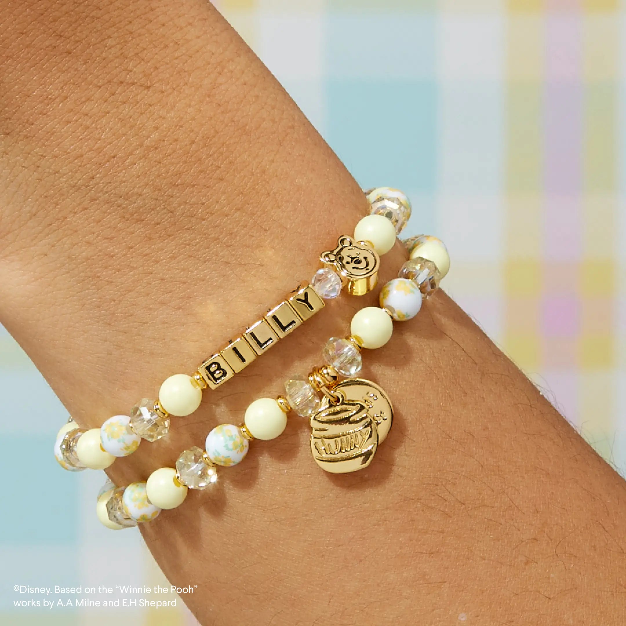Bracelet with 'BILLY' charm on wrist against a colorful background