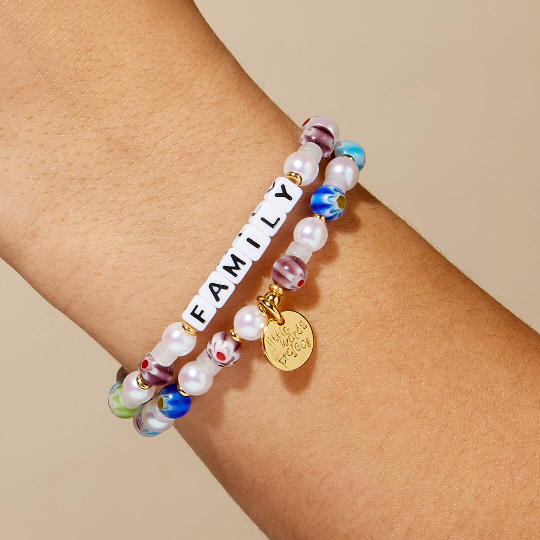 Beaded bracelet with 'FAMILY' word on wrist against beige background