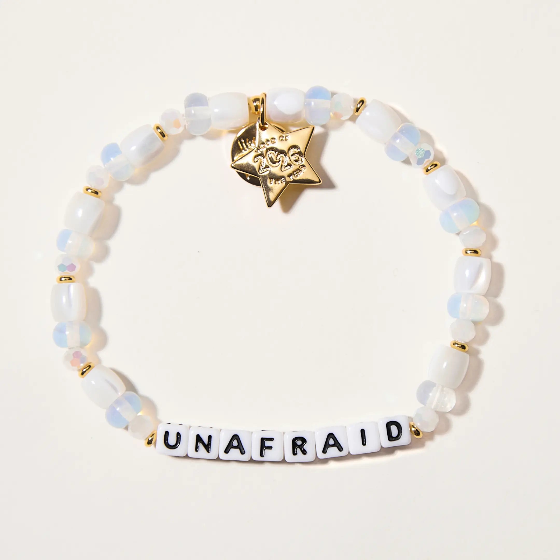 Bracelet with 'UNAFRAID' and gold accents on a light background