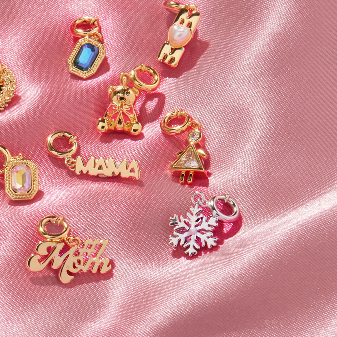 Collection of gold charms on a pink satin background