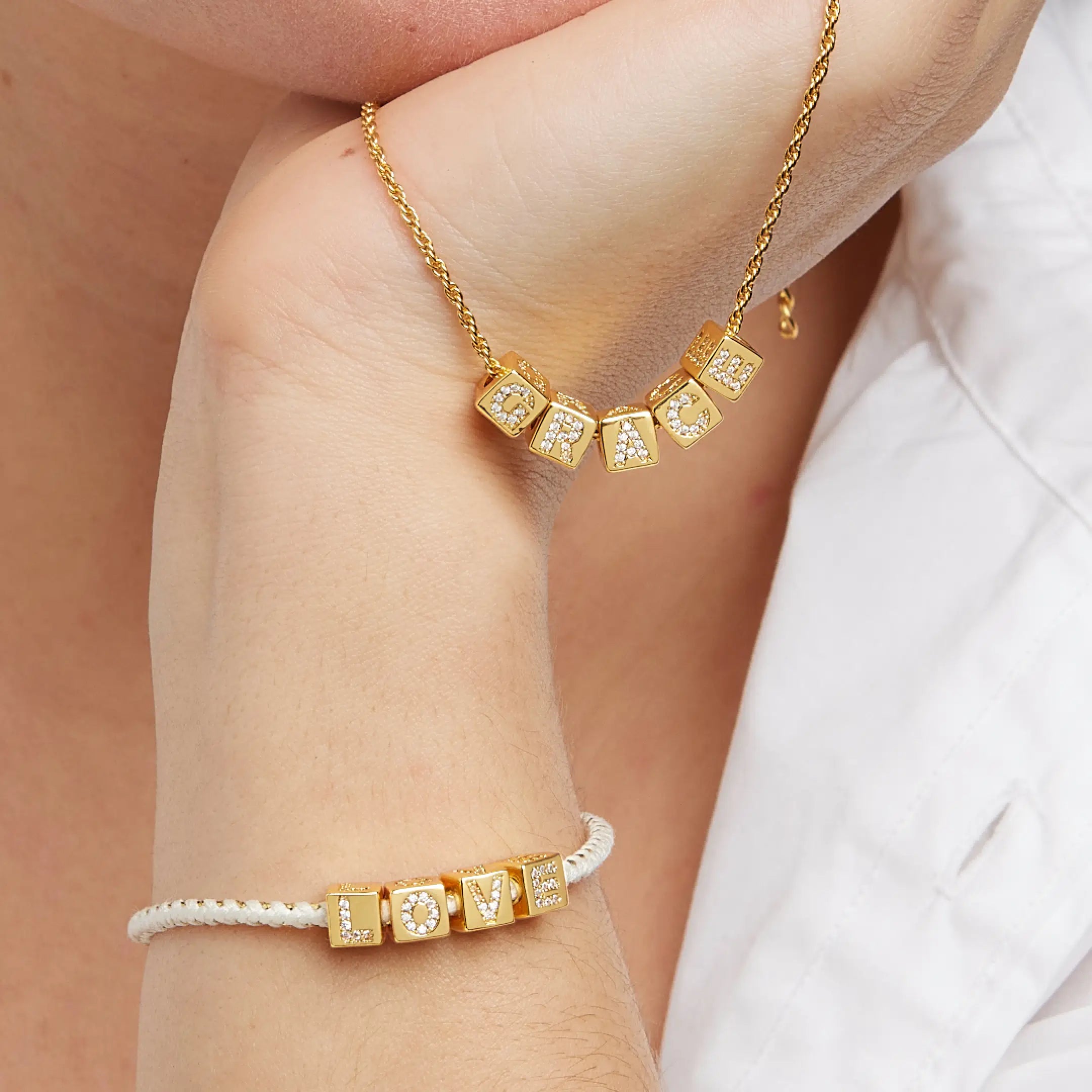 Gold bracelet with CZ accents on a wrist against a neutral background
