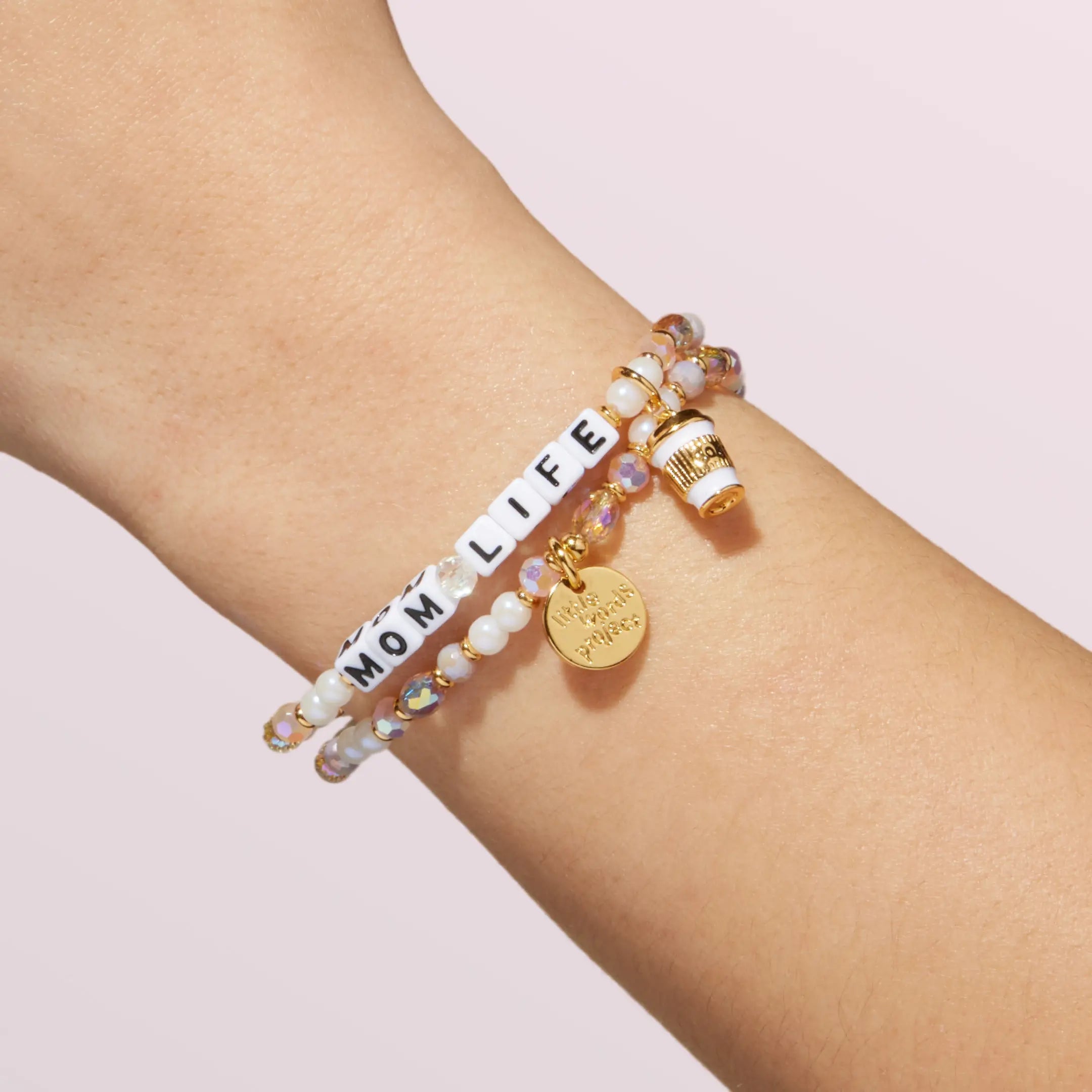 Bracelet with 'MOM LIFE' on a wrist against a light background