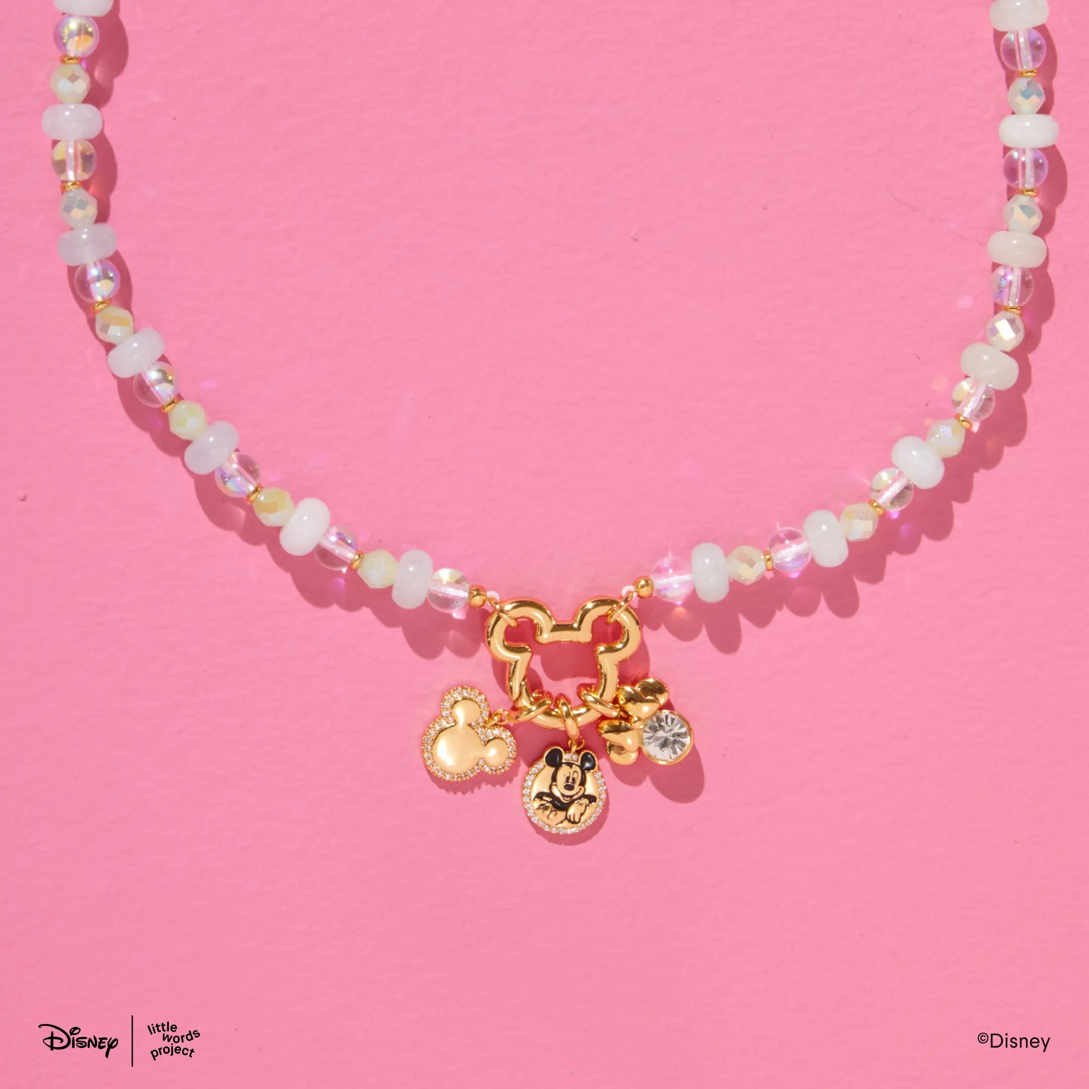 Mickey Mouse Charm Necklace Base from Disney Mickey and Friends on pink, close up of the pendant styled with gold plated Mickey Mouse and Minnie Mouse charms