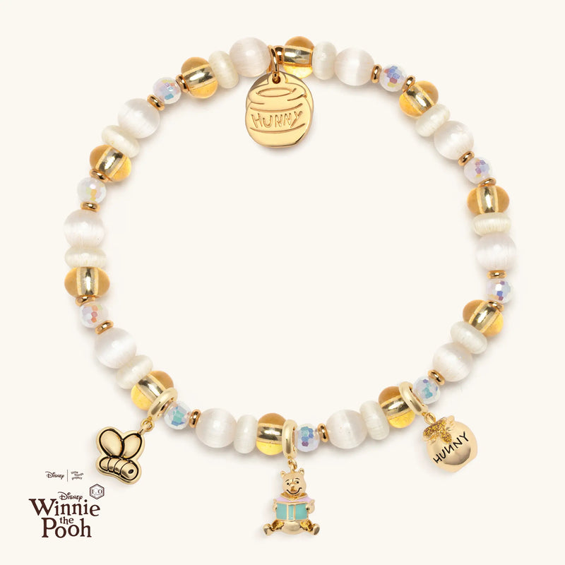 Bracelet with yellow and white beads featuring Disney's Winnie the Pooh charms on a white background.