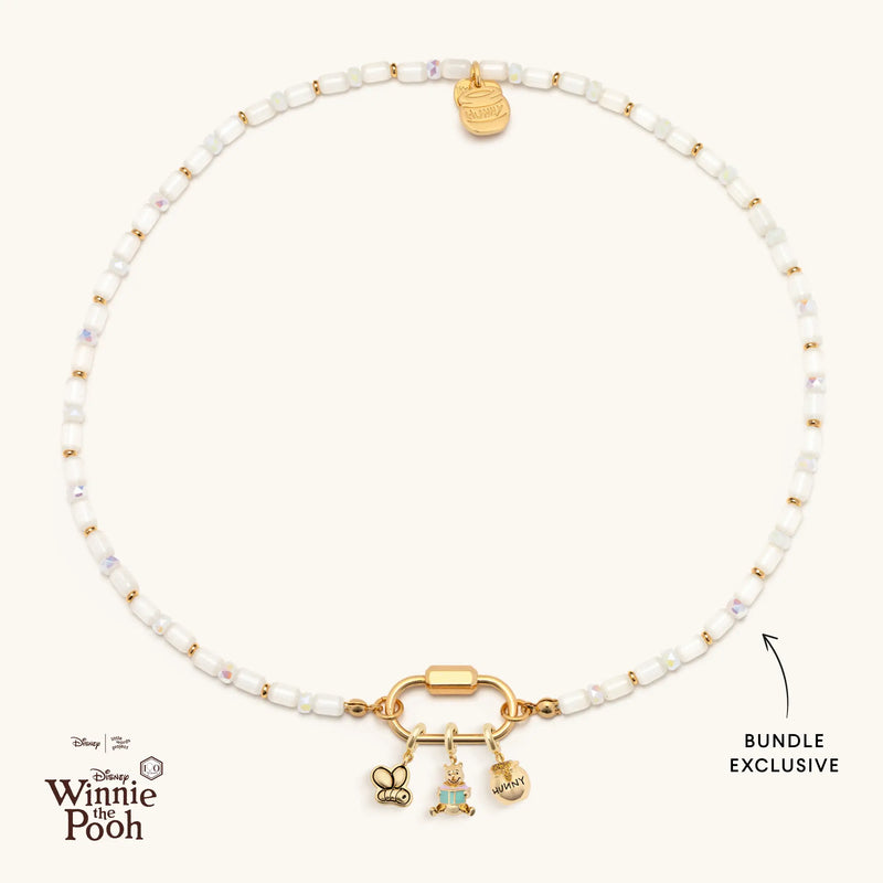 Necklace with gold charms and white beads on a white background, featuring Disney Winnie the Pooh logo.
