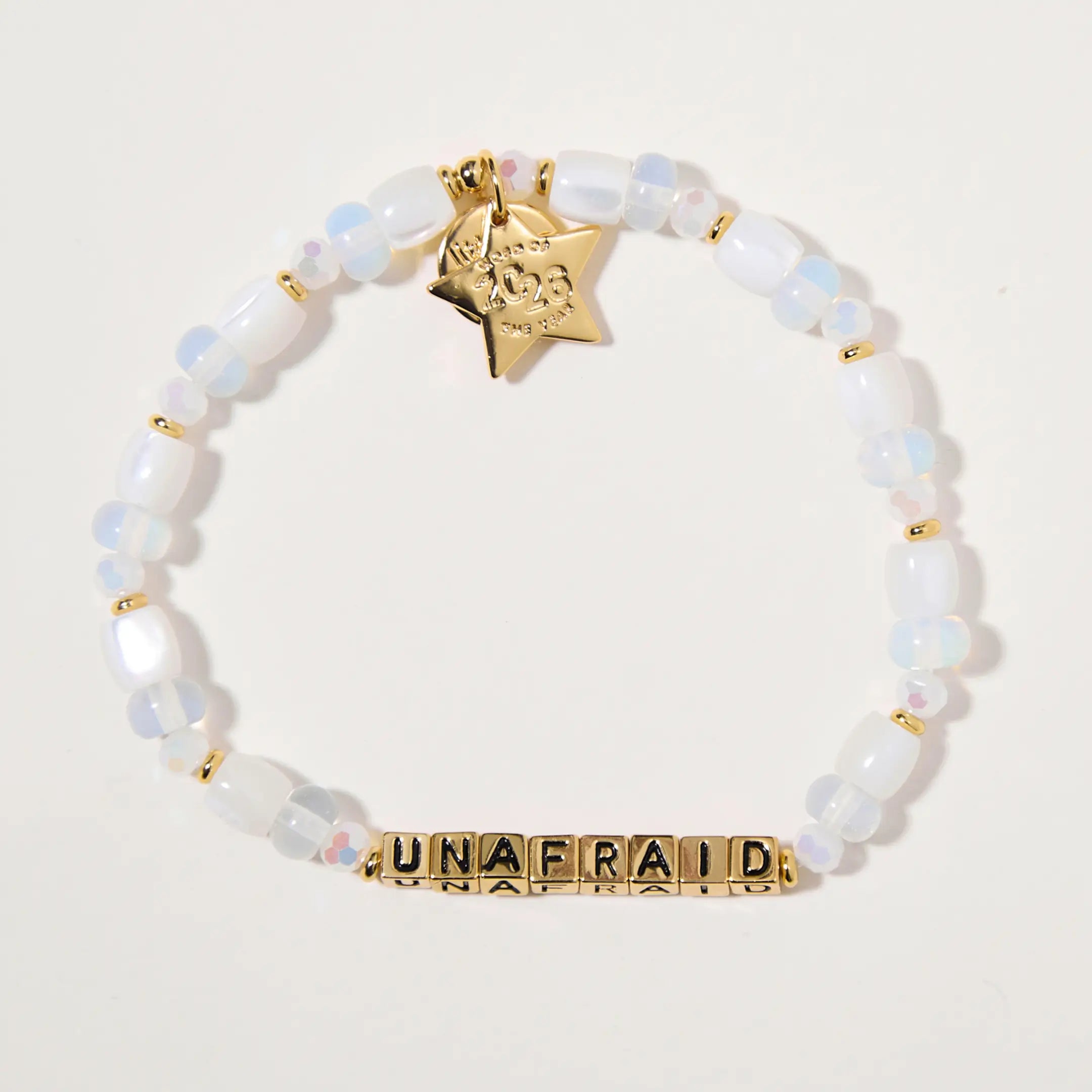 Bracelet with white beads and gold accents on a light background