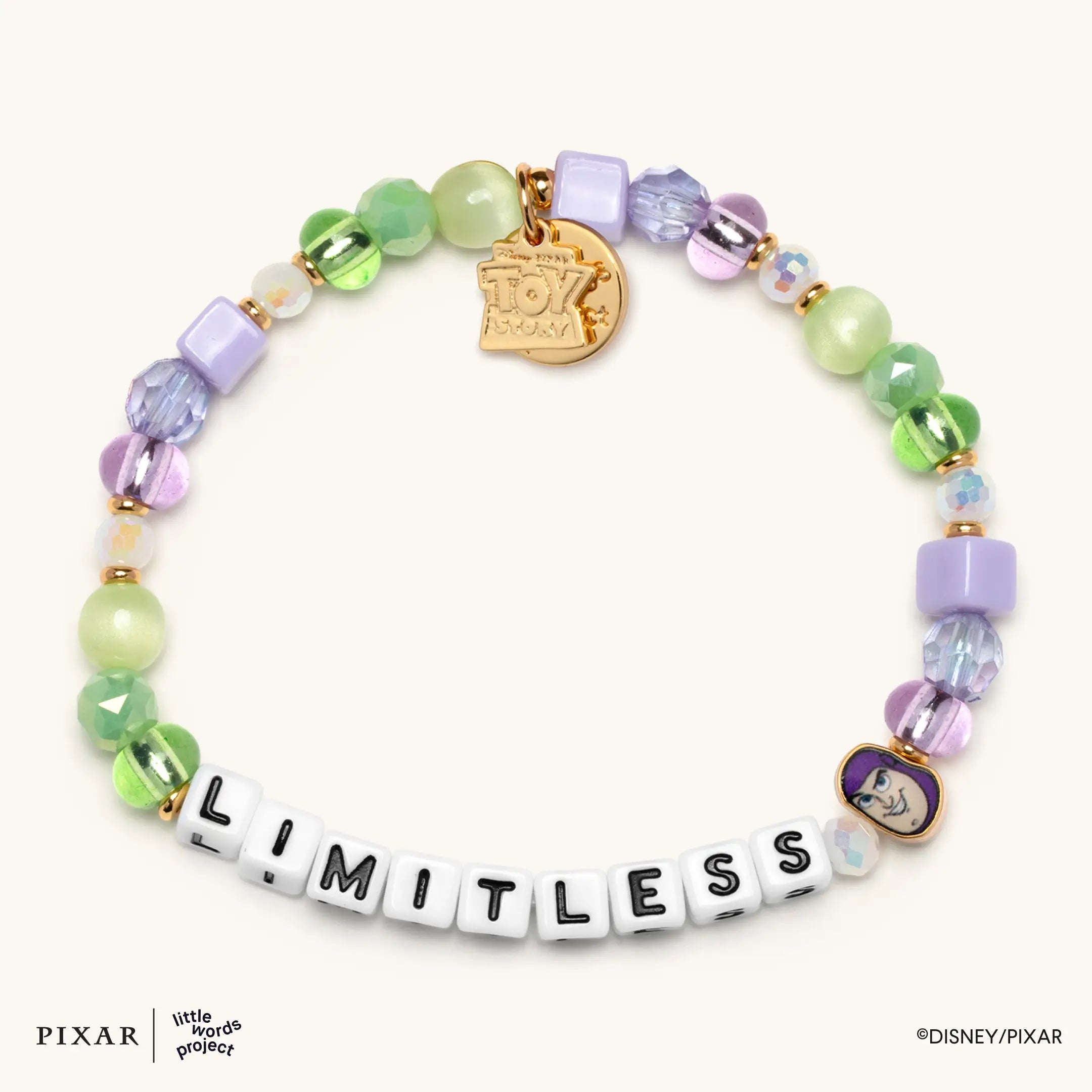 Limitless bracelet from the You've Got a Friend Toy Story set, green and purple beads with a gold charm, flat lay