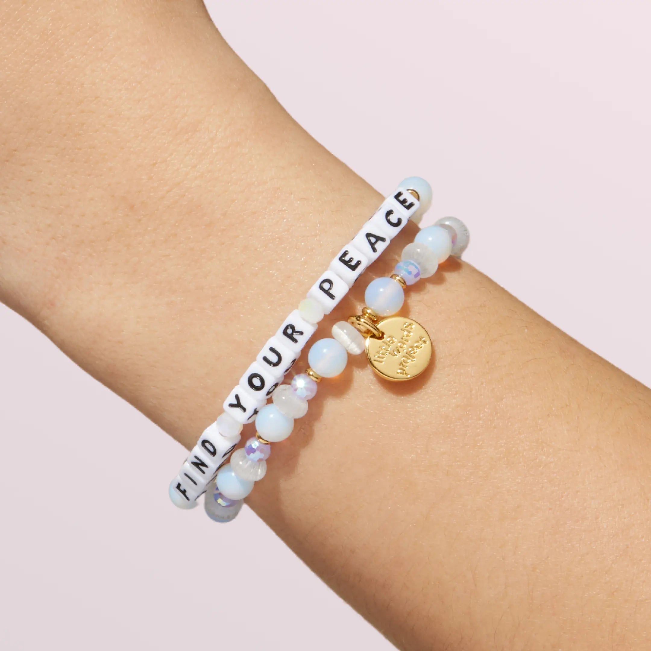 Bracelet with 'Find Your Peace' on a wrist against a light background
