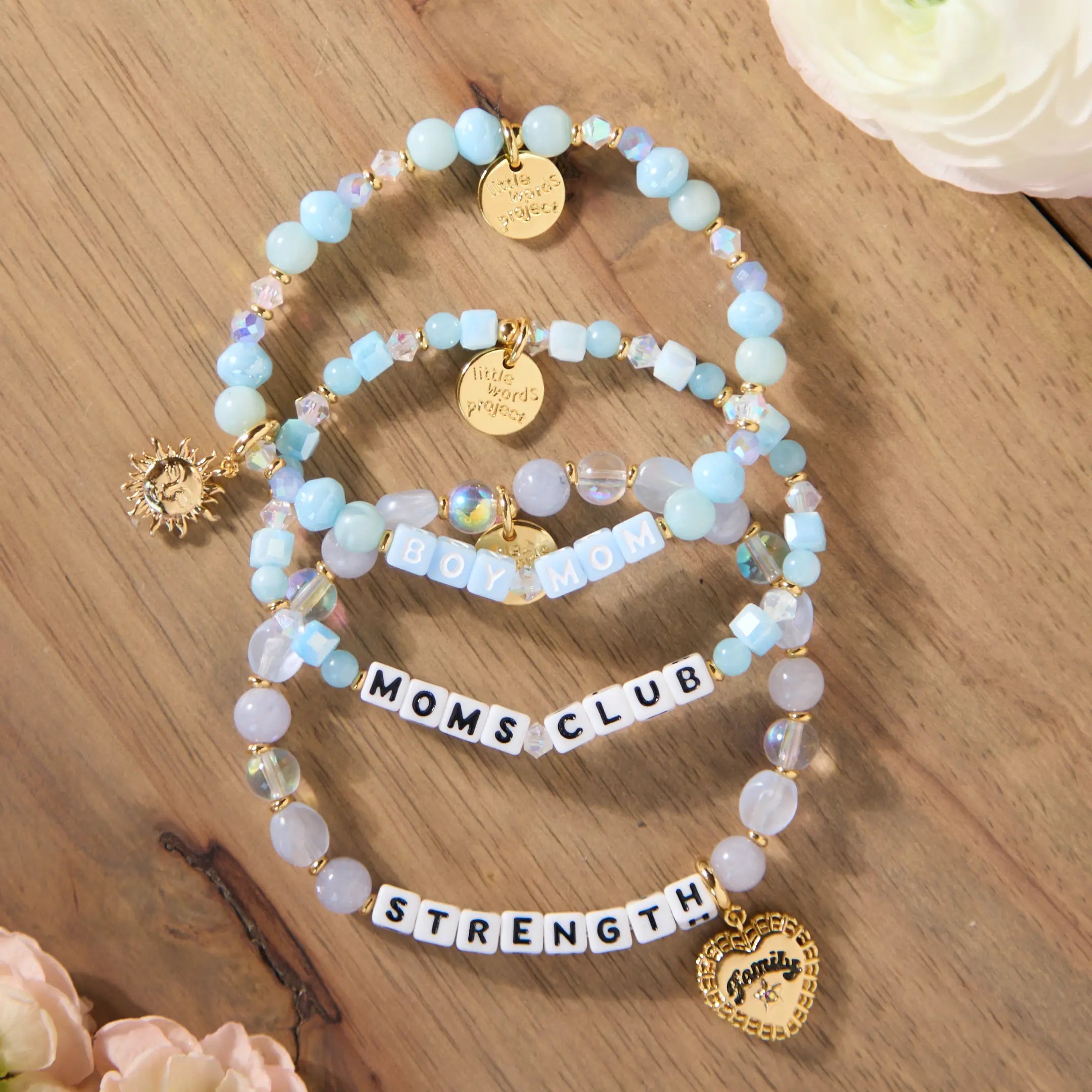 Set of beaded bracelets with charms on a wooden surface