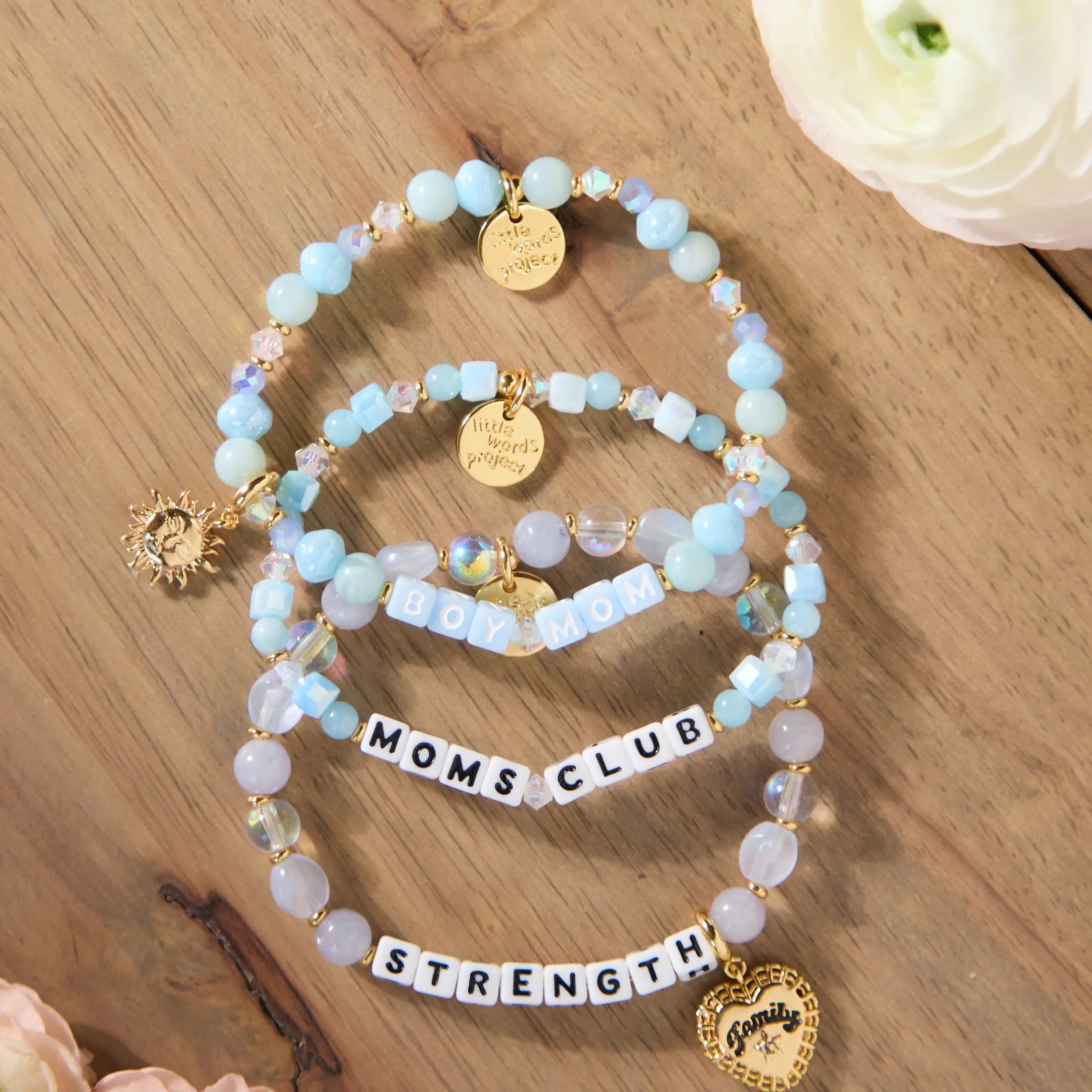 Set of beaded bracelets with charms on a wooden surface