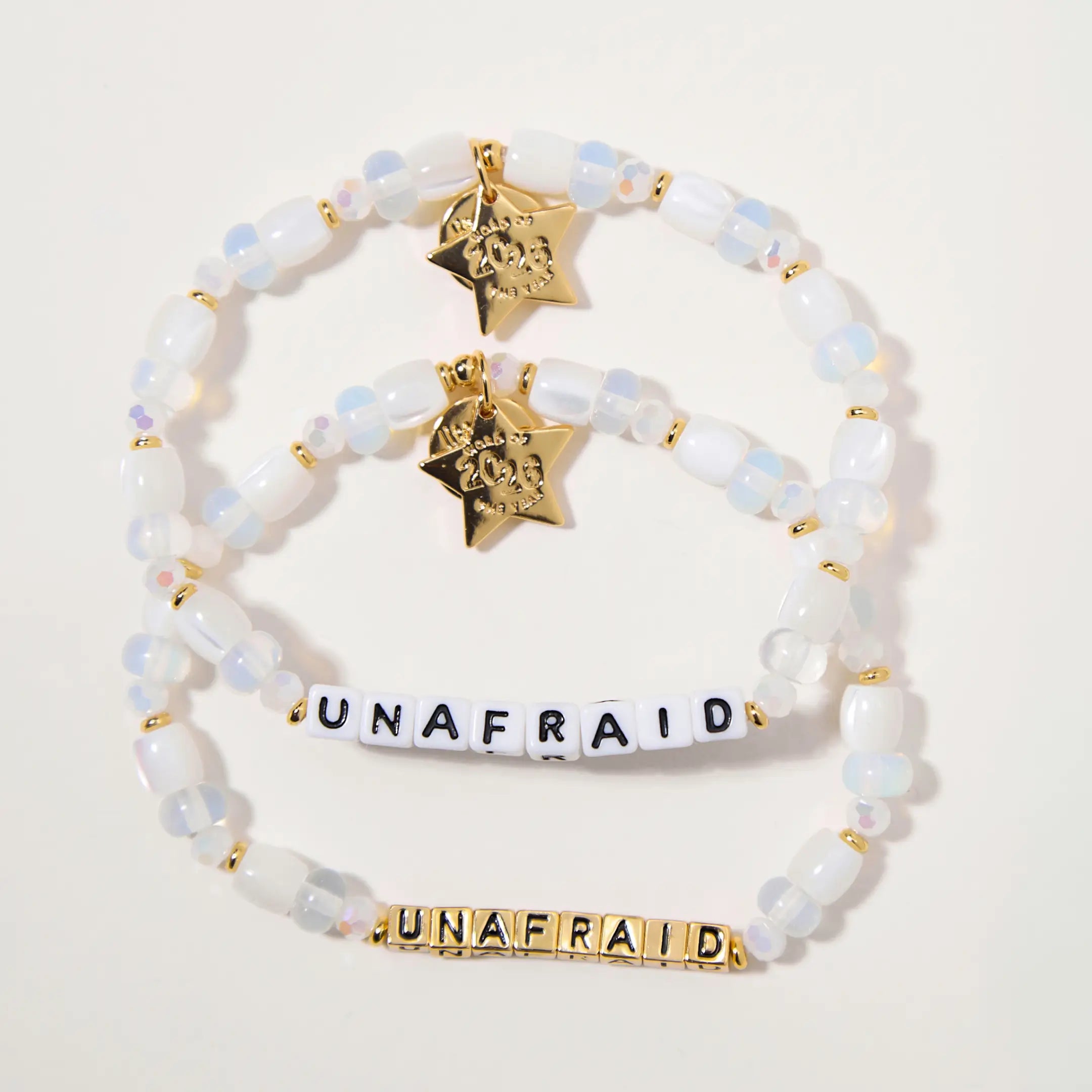 Set of beaded bracelets with star tags and 'UNAFRAID' text on a light background