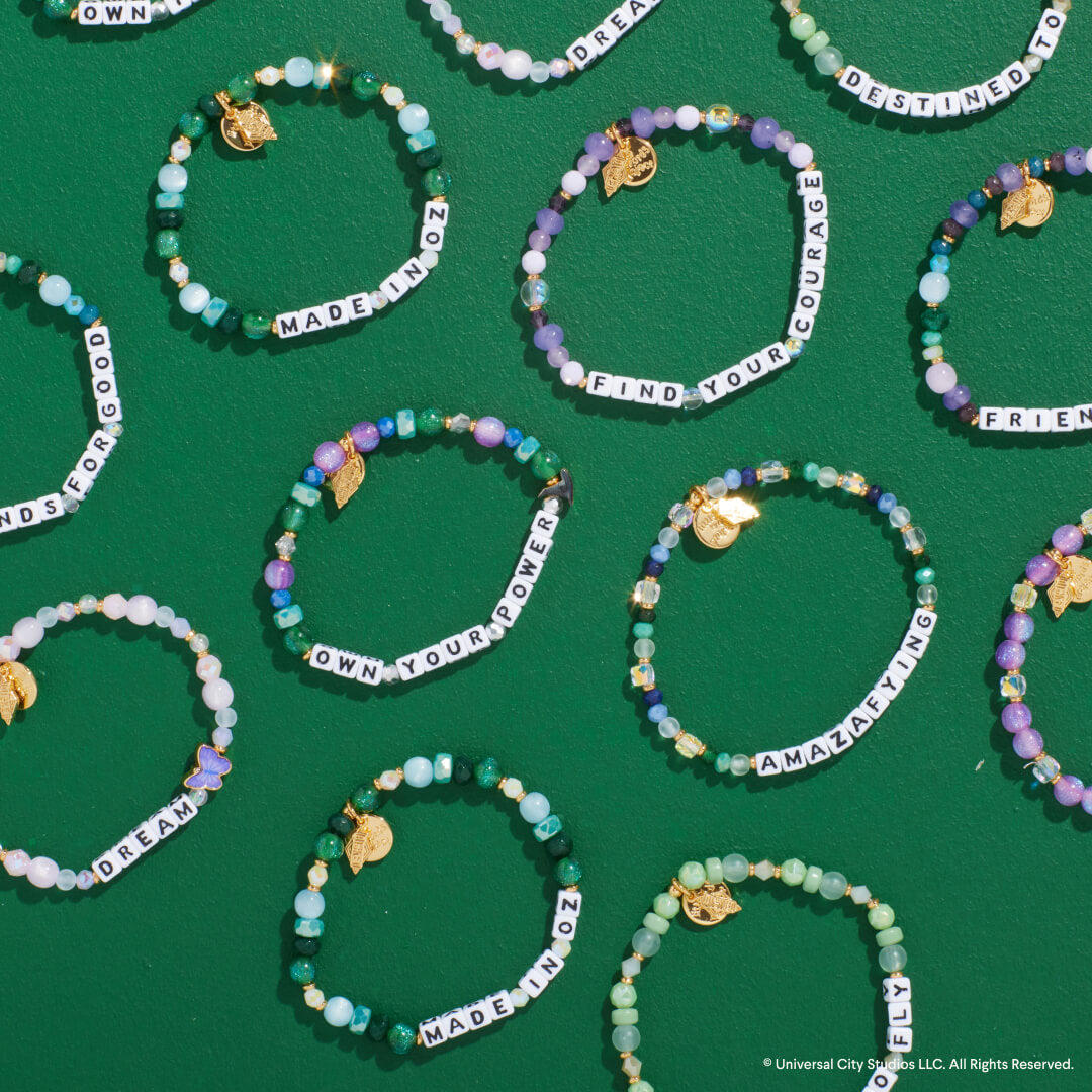 Beaded bracelets with motivational phrases on a green background