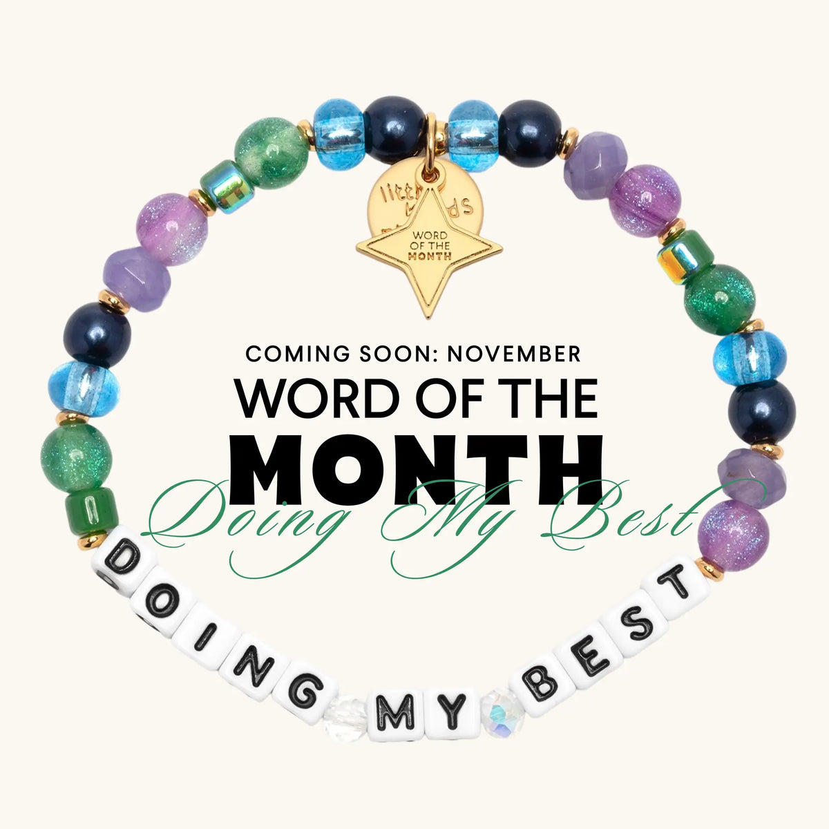 Coming soon: Doing My Best November Word of the Month bracelet with white letter beads, purple, navy, blue, and green glass beads, and a gold star Word of the Month charm, flat-lay graphic on cream background