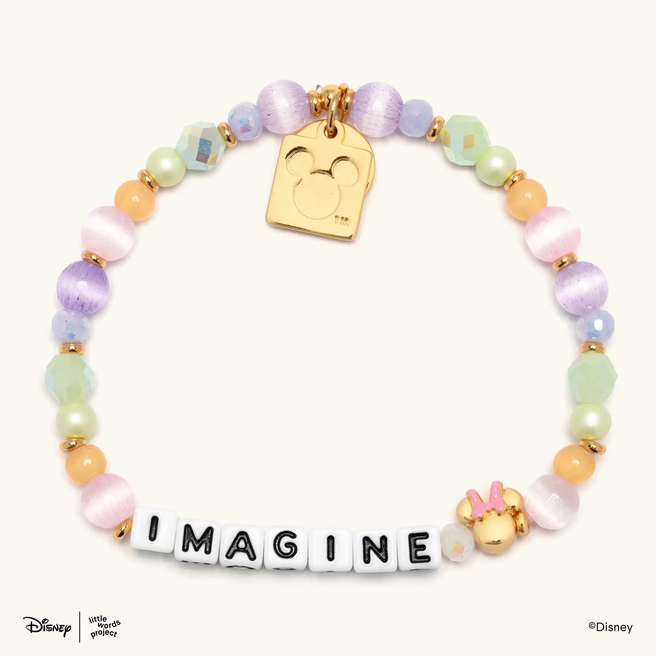 Imagine Disney Mickey and Friends bracelet flat lay on cream with pastel purple, green and orange beads, a Minnie Mouse bead and a gold plated casted Mickey Mouse tag charm