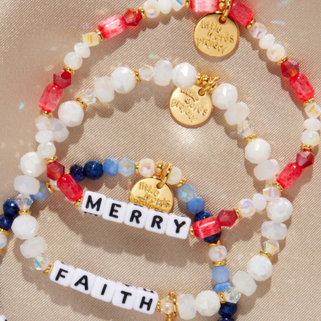 Colorful beaded bracelet with gold charms and 'Merry & Faith' message on a beige background