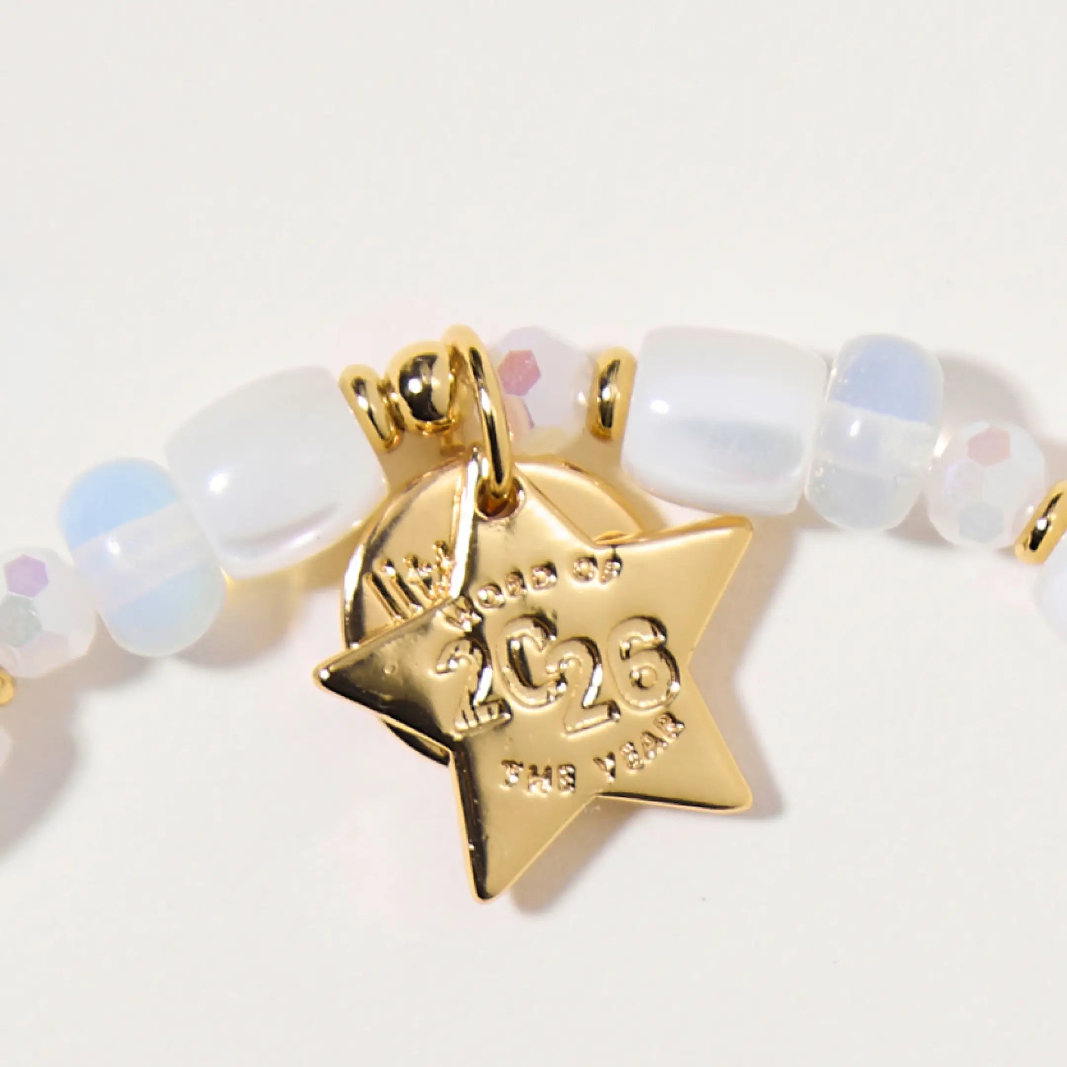 Bracelet with a gold 'Word of the Year 2026' star tag on a light background