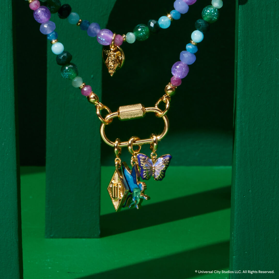 Necklace with butterfly charm on a green background